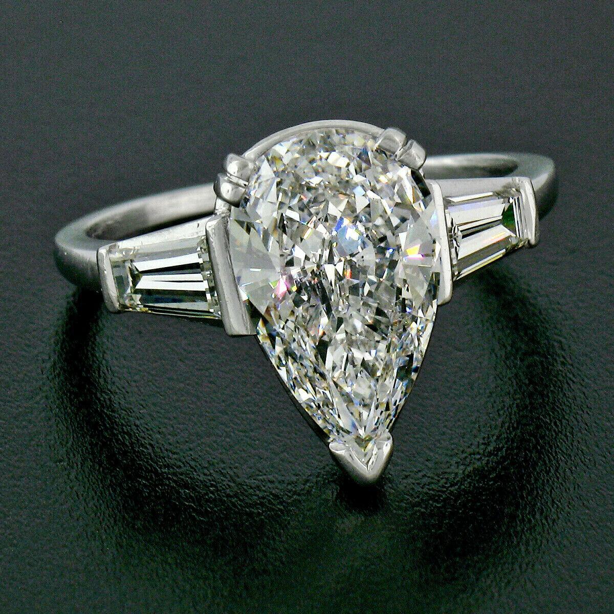This breathtaking vintage engagement ring was hand crafted in solid .900 platinum and features a jaw dropping, GIA certified pear brilliant cut diamond which is neatly and very finely prong set at the center of this classically designed ring. The