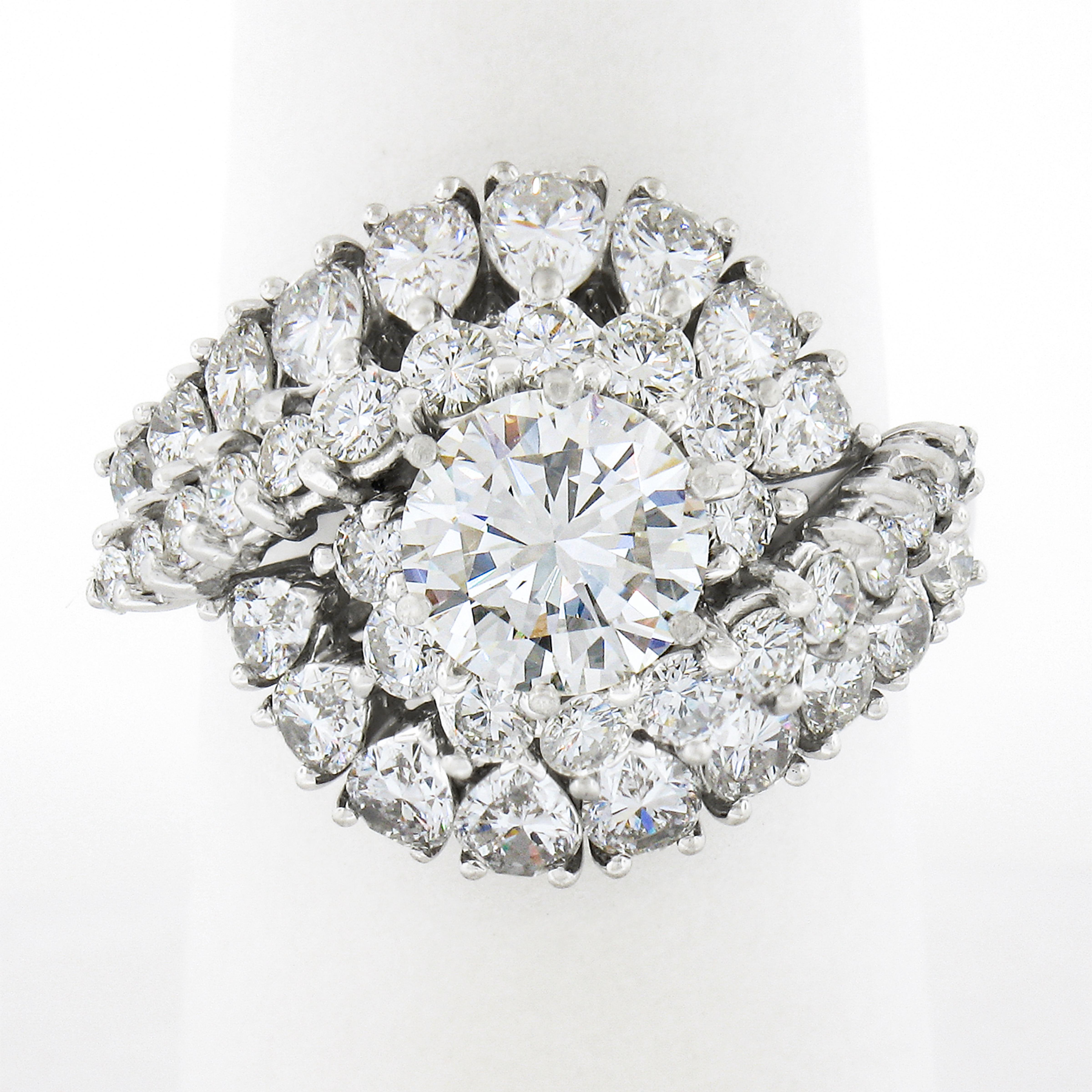 This truly jaw dropping engagement or cocktail diamond ring is very well crafted in solid platinum and is completely drenched in very fine quality diamonds throughout this incredible, domed, swirl design. It features a gorgeous, GIA certified,