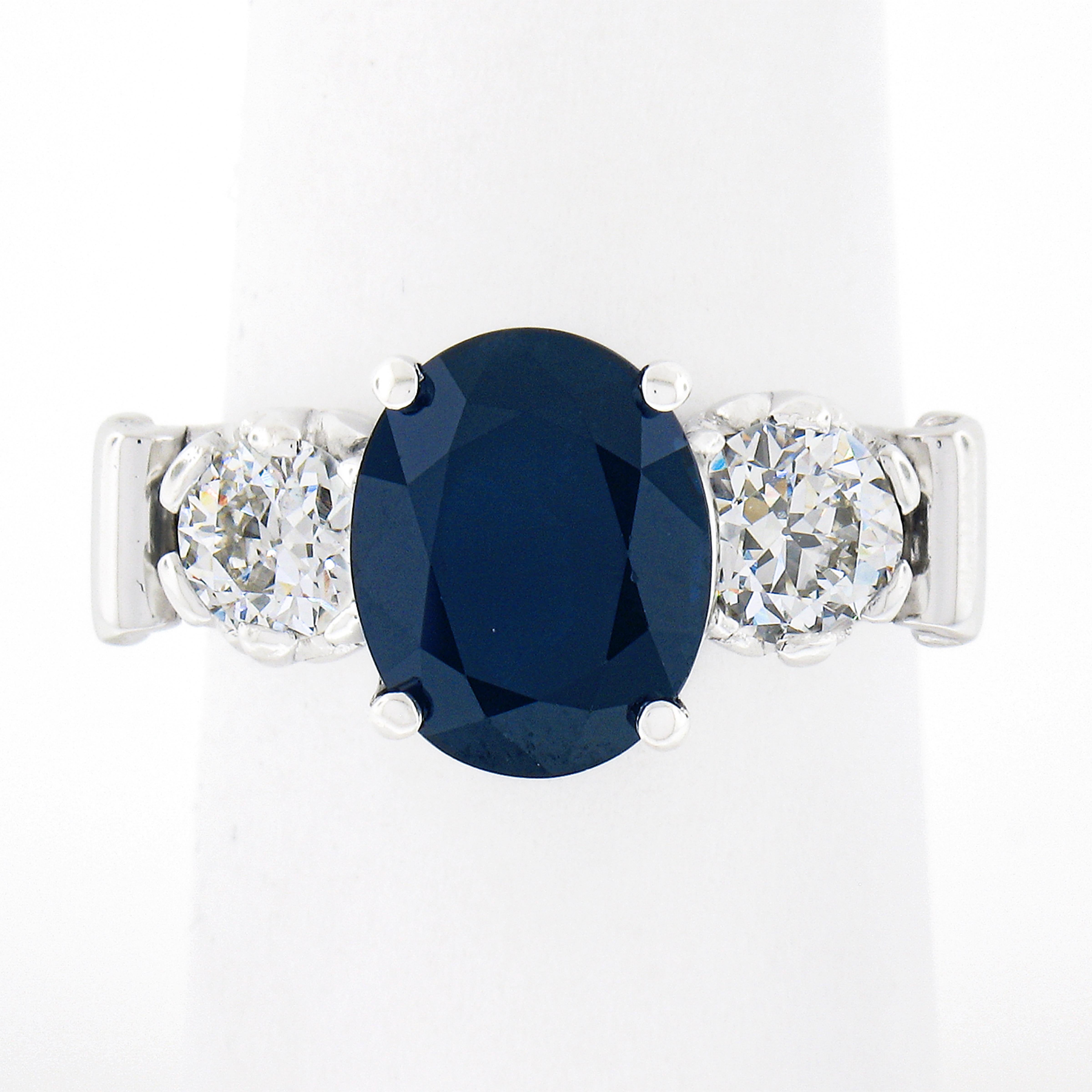 This incredible sapphire and diamond vintage ring is crafted from solid platinum and features a beautiful, GIA certified, sapphire solitaire neatly prong set at the center. The center stone has an oval cut and displays the most gorgeous deep blue