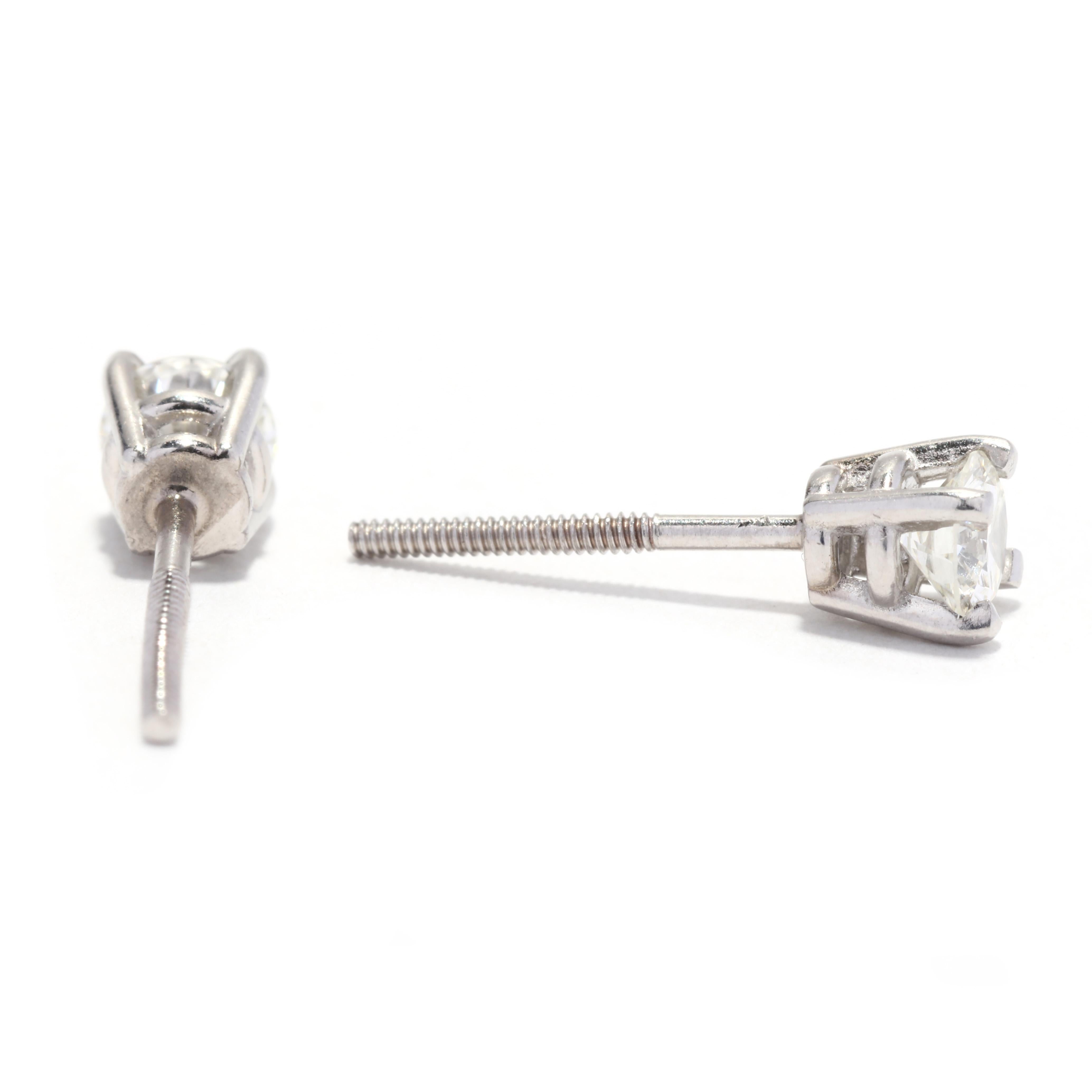 A pair of vintage platinum diamond solitaire screw on earrings. This simple stud earrings feature prong set, round brilliant cut diamond center stone weighing approximately .50 total carats and with pierced screw back closures.

Stones: 
- diamonds,
