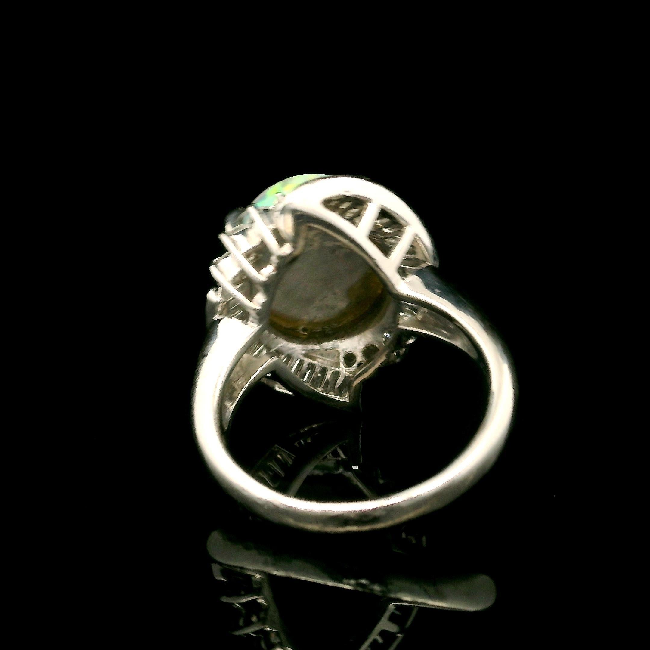--Pierre(s) :...
(1) Opale véritable naturelle - Cabochon ovale - Serti - Couleur blanche avec un très beau jeu de couleurs - 13.8x11.7mm / 4.37ct (exact)
Nombreux diamants naturels authentiques - taille ronde, brillante et baguette - sertis à