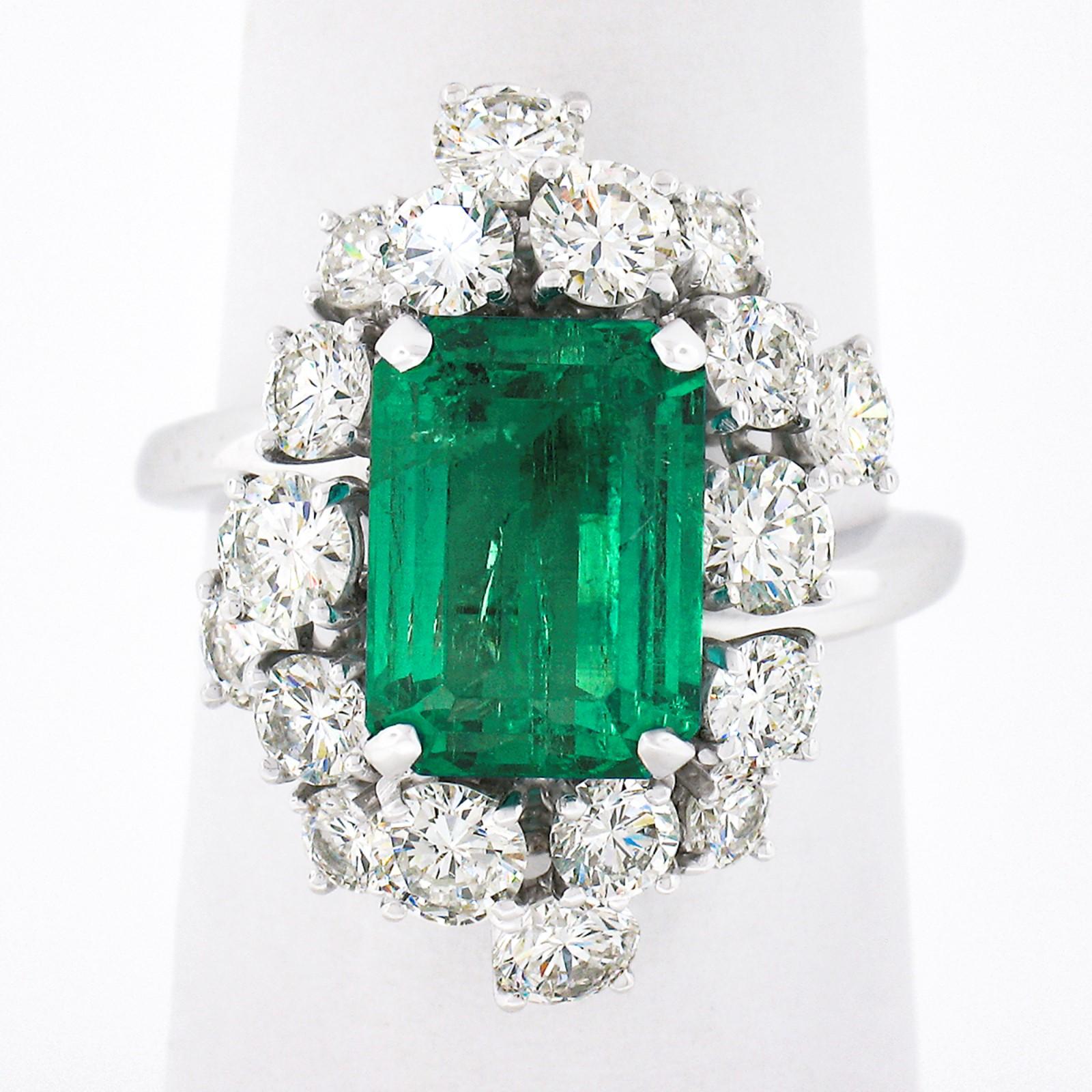 Here we have a truly jaw dropping vintage emerald and diamond cocktail ring, crafted in solid platinum. The ring features a gorgeous, GIA certified, natural emerald stone that displays the most attractive and rich green color with amazing amount of