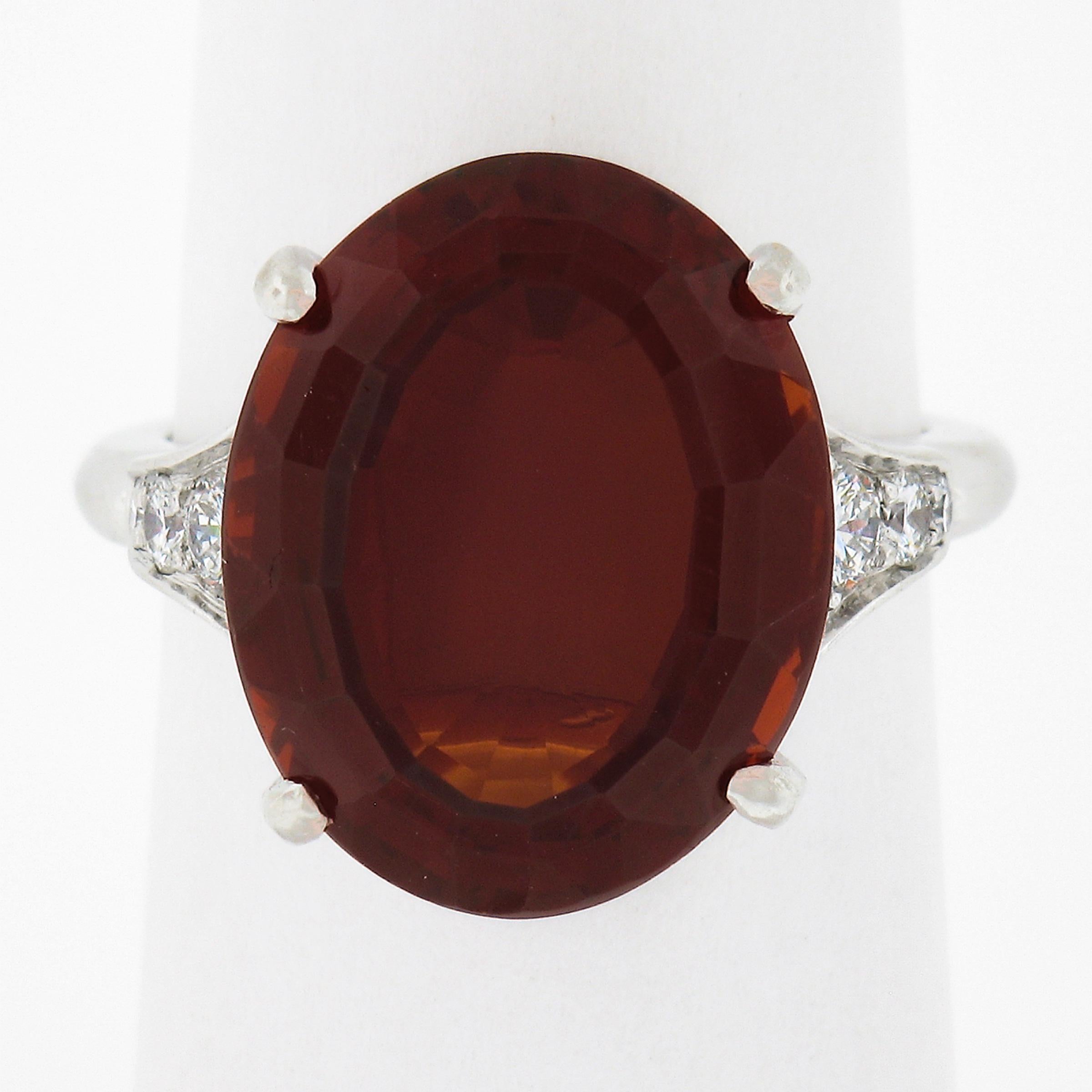 This gorgeous solitaire cocktail ring is crafted in solid platinum and features a top quality and rare oval step cut natural madeira citrine that is neatly set at the center displaying a beautiful and rich red orange color with remarkable amount of