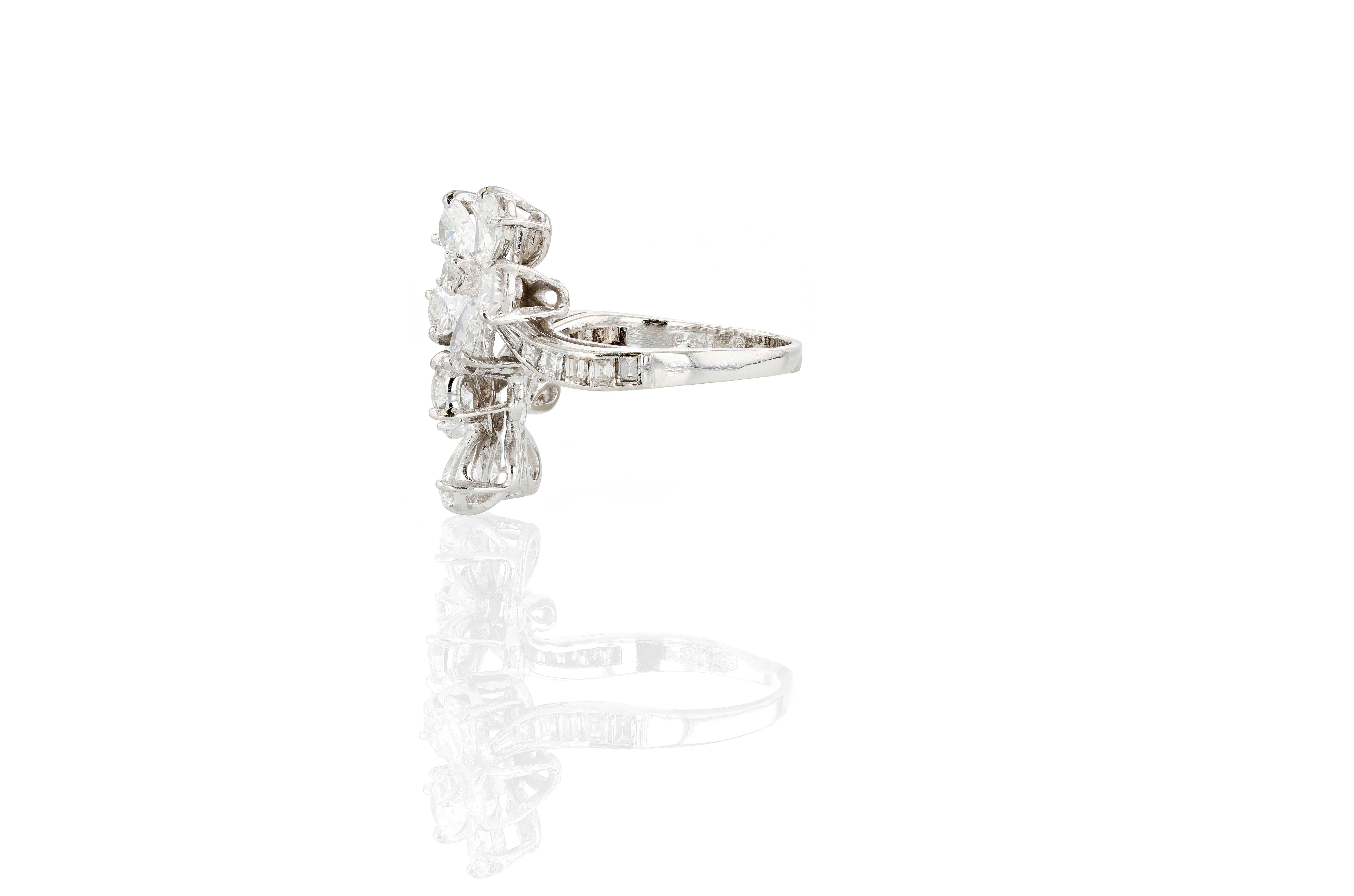 A platinum and diamond floral bypass ring of exceptional quality.

The ring centers 10 pear shaped diamonds of approximately 0.30 carats each, E to F in color and VS2 to SI1 in clarity. The central flower motifs are accented on the shoulders of the