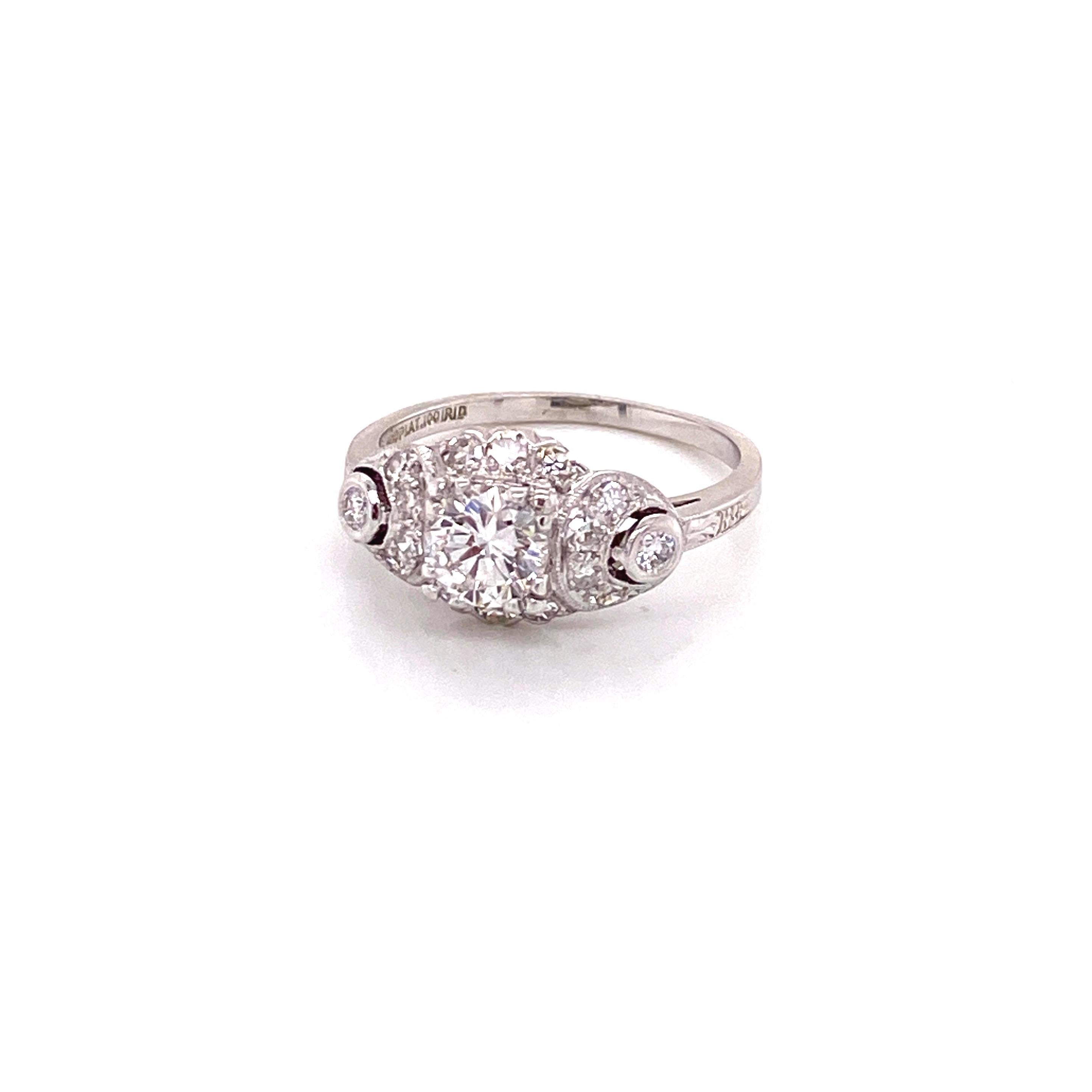 Vintage platinum Art Deco diamond ring with diamond crescents accents. The center round diamond weighs .63ct, and has G color, and VS2 clarity. The diamond is set low in a triple prong head with 3 single cut diamonds on top and bottom. Each crescent