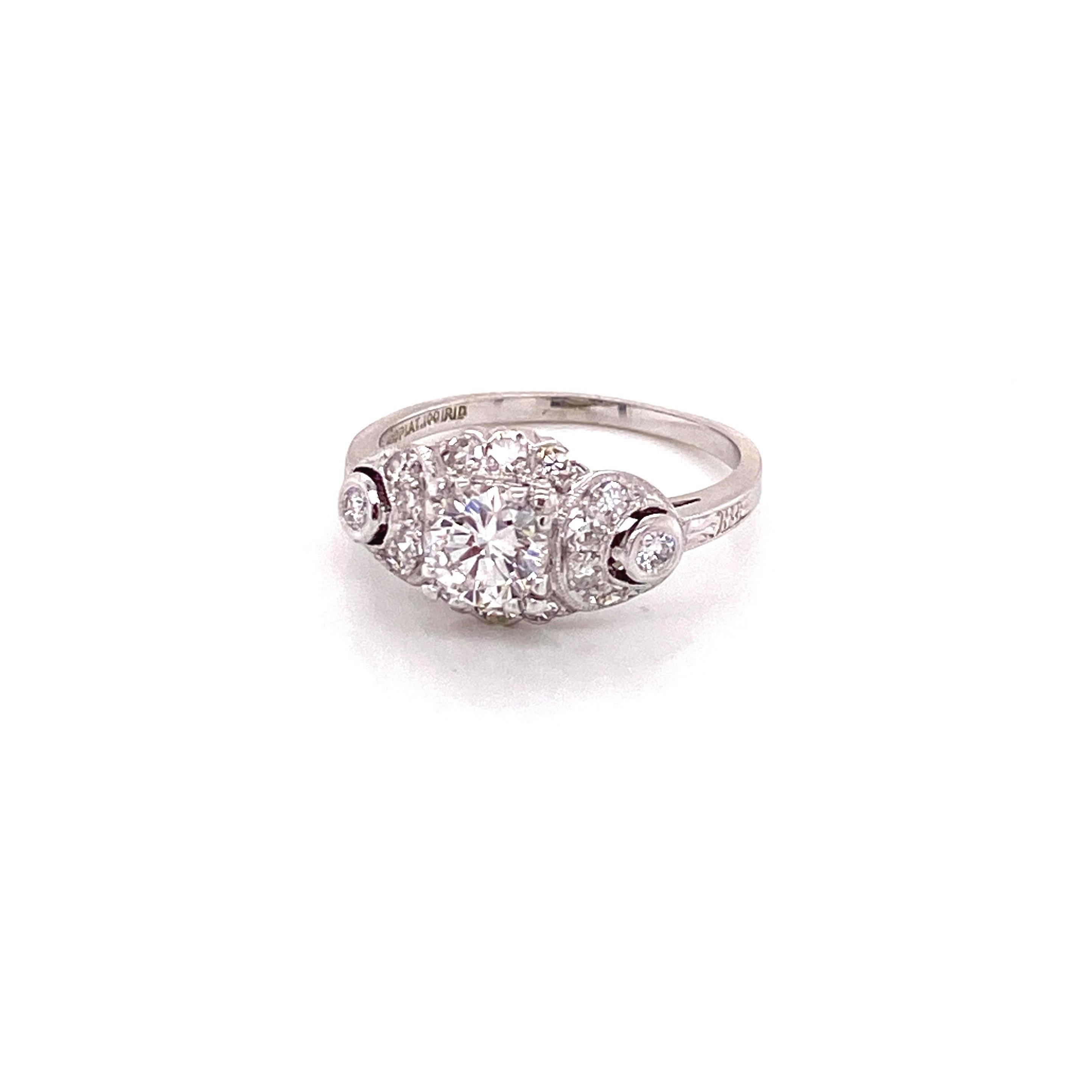 Anello di diamanti Art Deco vintage in platino con accenti di diamanti a mezzaluna. Il diamante centrale rotondo pesa .63ct, ha un colore G e una purezza VS2. Il diamante è incastonato in basso in una testa a tre punte con 3 diamanti a taglio