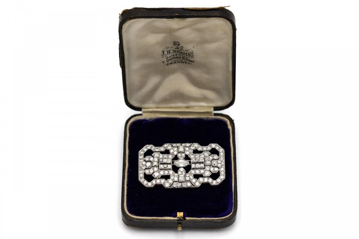 Antique platinum Art Deco brooch from the 1930s.

The main diamond in a fancy cut, VS2 clarity and H color, weighing 0.80 ct. 

The brooch is decorated with 14 VS-P1/H-J square diamonds with a total weight of 2.33ct

Additionally, the brooch has 106