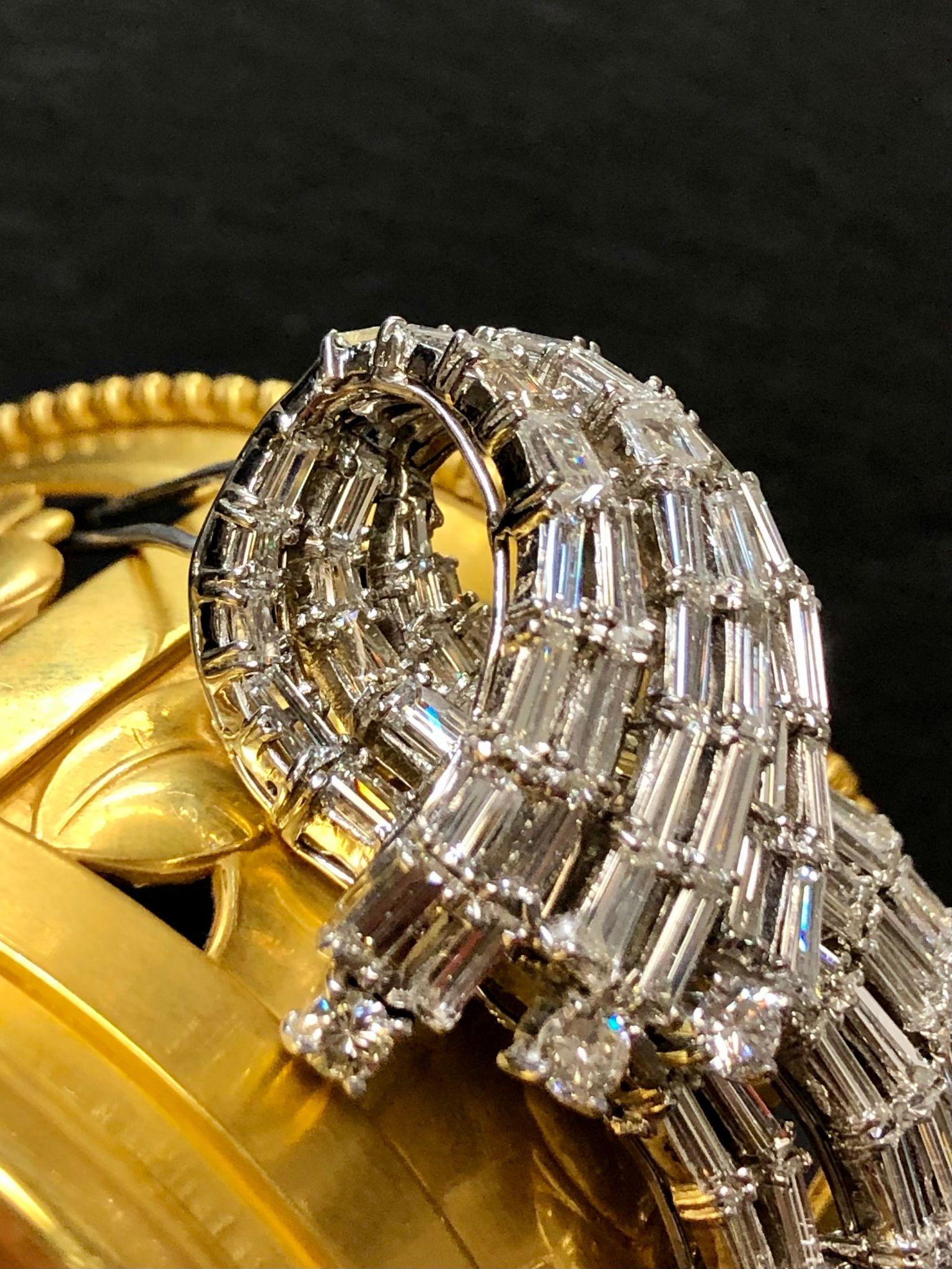 An impressive brooch done in platinum and set with numerous large tapered and square baguette and round diamonds with an approximate total weight of 12cttw and all stones are G-J color and Vs1-Si1 in clarity.

Dimensions/Weight
2 1/4” by 1 1/4”.
