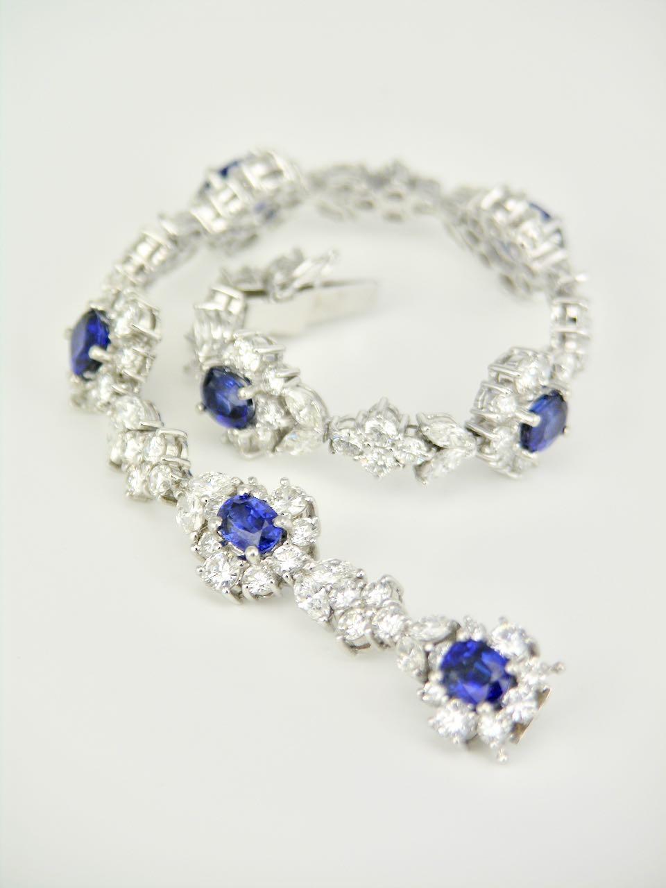 A platinum blue sapphire and diamond bracelet - a very pretty bracelet of seven oval royal blue natural sapphires set in amongst 112 diamonds arranged in gradated clusters and interspersed with marquis and round brilliant cut diamonds. These are set