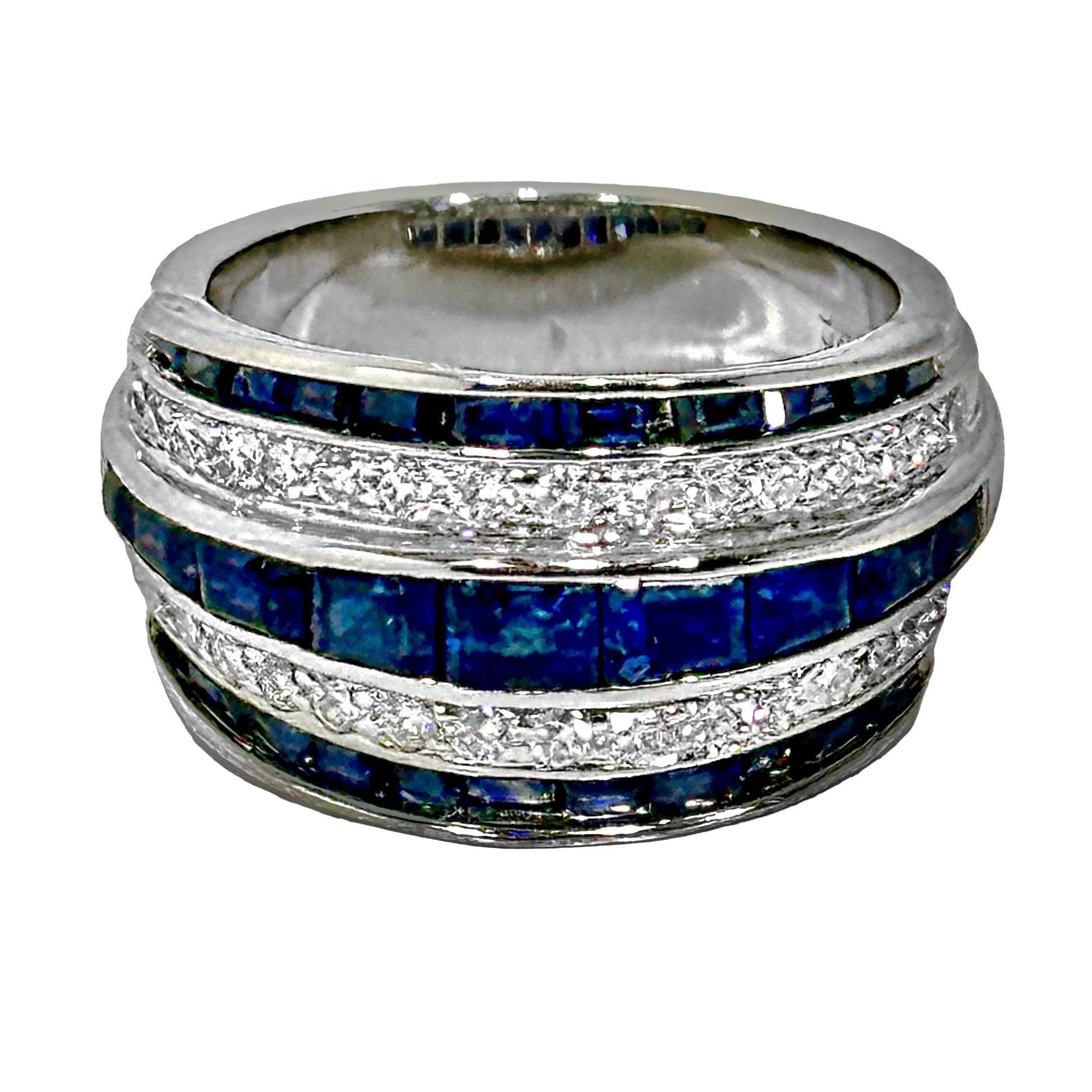 This handsome, classic style platinum ring is set with one row of deep blue calibre cut sapphire across the middle, flanked above and below it with a row of brilliant cut diamonds, and finished at the top and bottom with another row of calibre cut