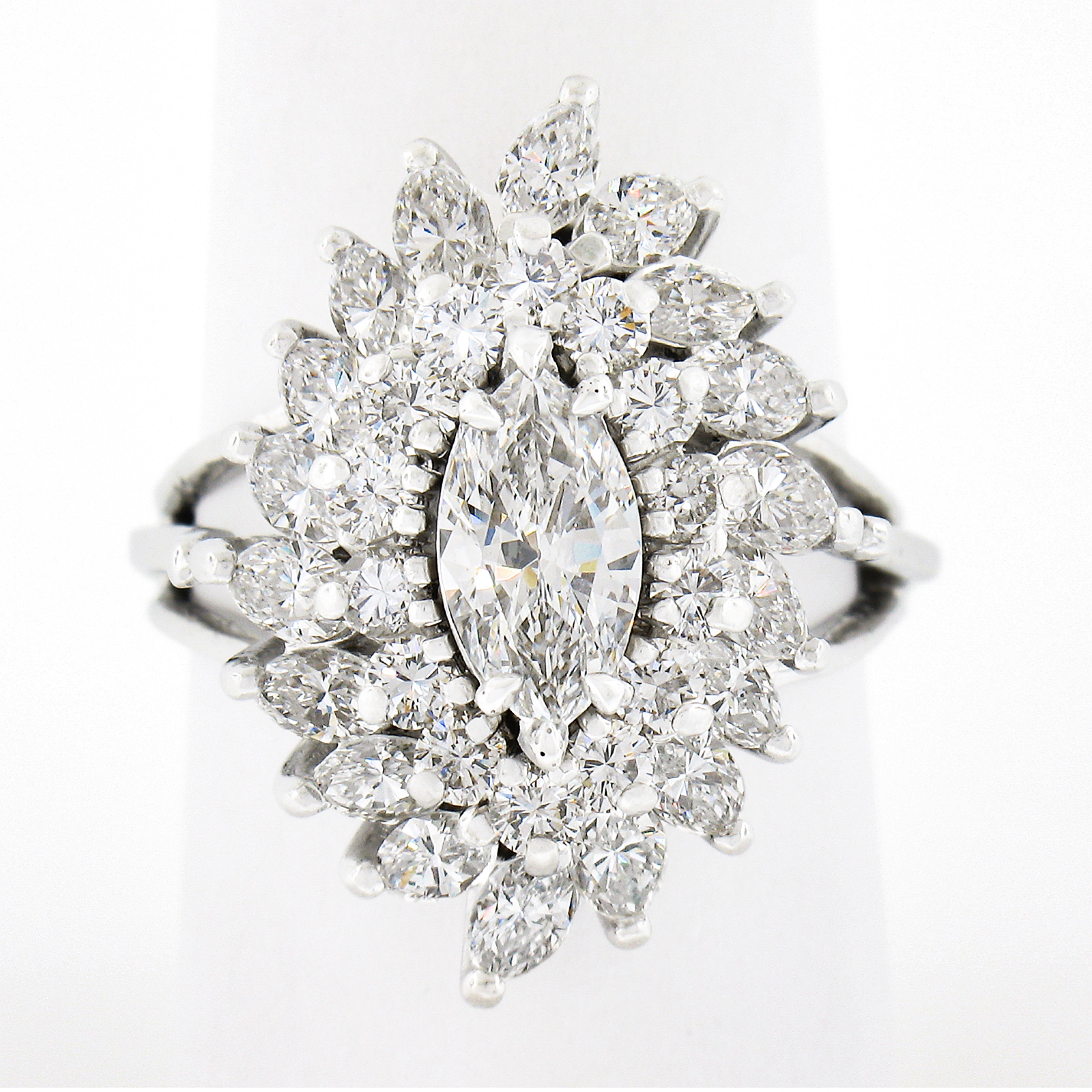This truly jaw dropping engagement or cocktail diamond ring is crafted in solid platinum and is completely drenched in TOP QUALITY diamonds throughout this incredible and substantial design. It features a gorgeous, GIA certified, marquise cut