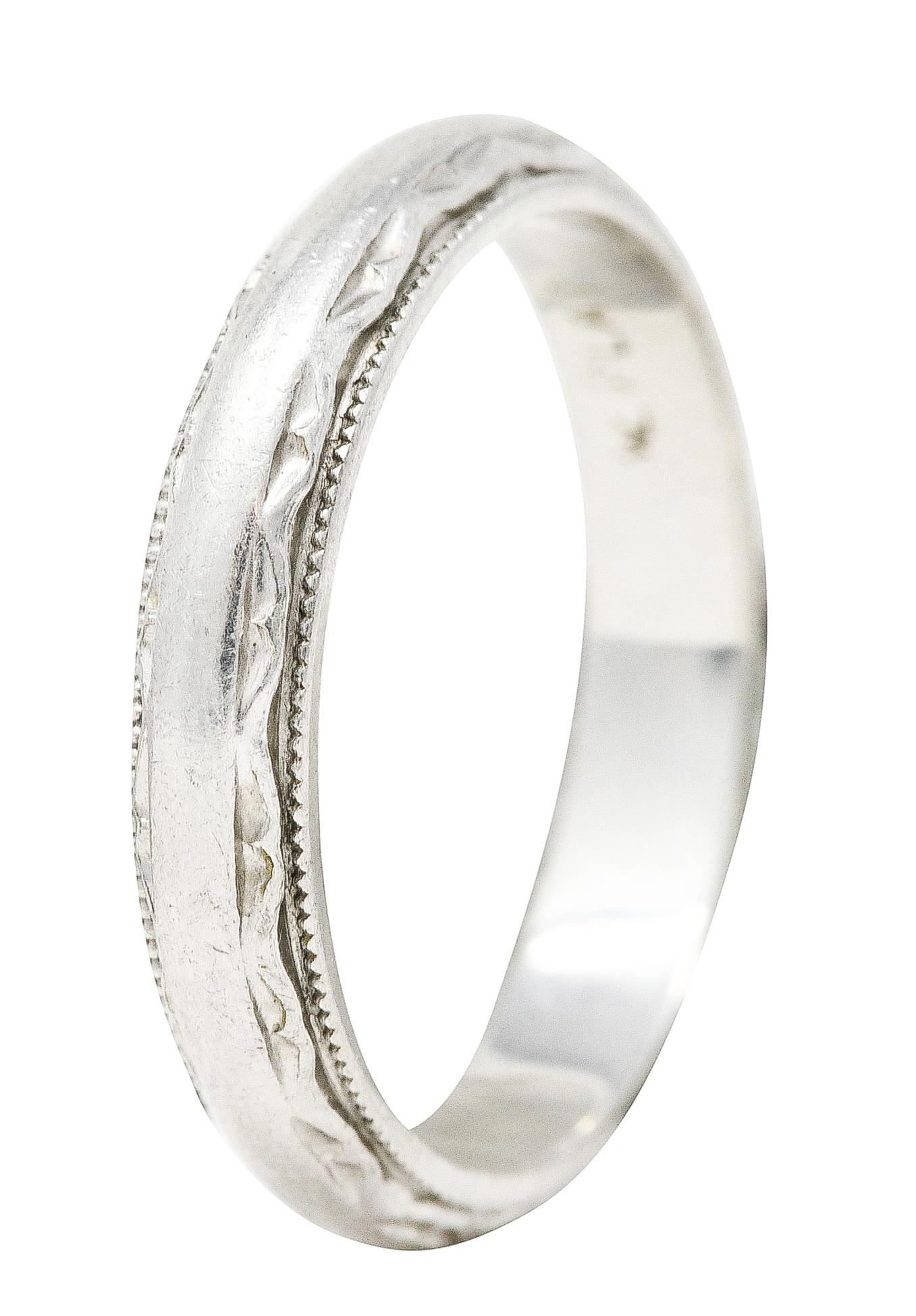 Band ring features a grooved scallop design fully around. With milgrain surround. Stamped plat for platinum. Inscribed 'Love Joe 9-5-99'. Circa: Late 20th century. Ring size: 6 1/4 and not sizable. Measures: North to South 3.5 mm and sits 1.5 mm