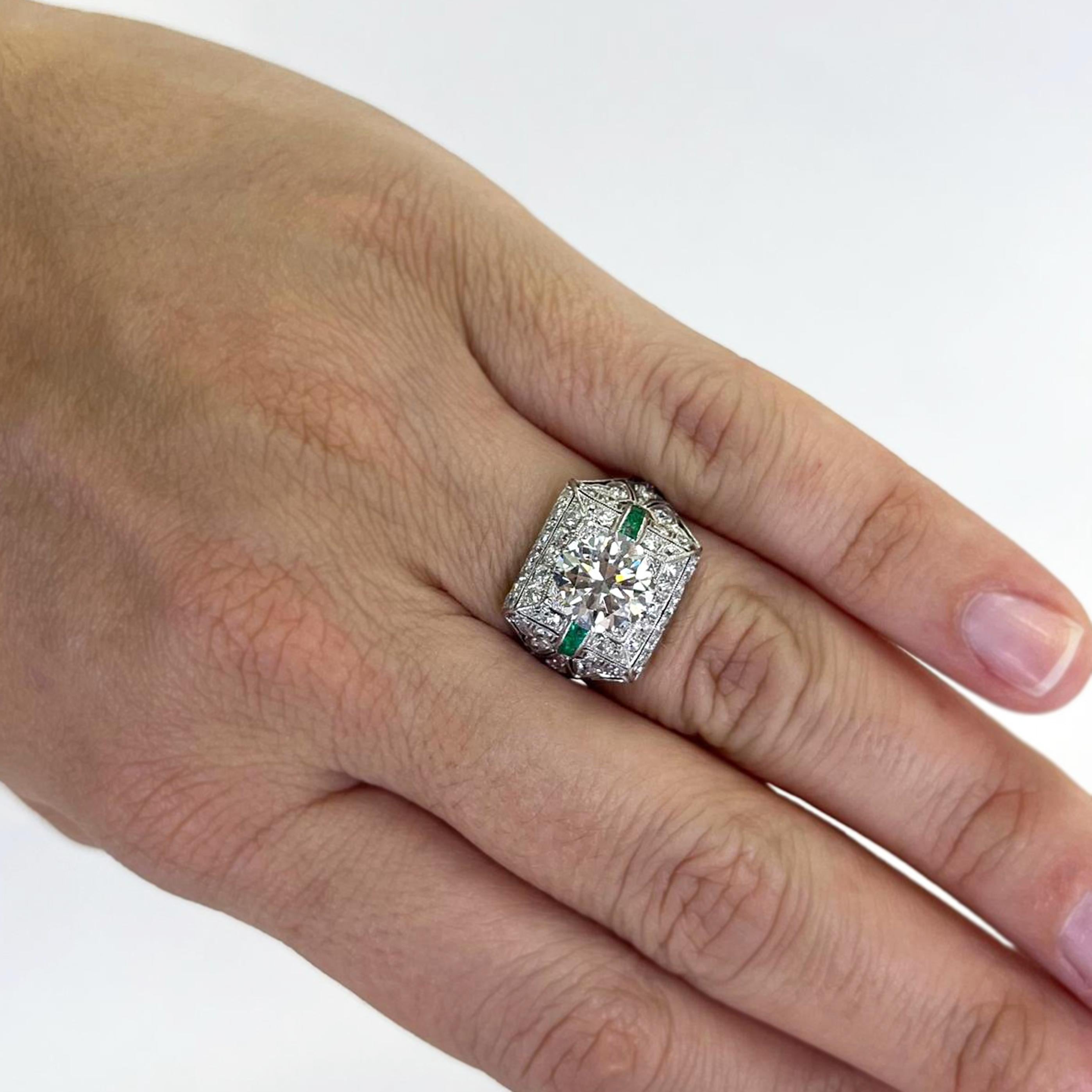 Anello vintage in platino con un diamante rotondo di transizione da 2,30 carati con purezza VS2 e colore J, accentato da 46 diamanti taglio vecchio europeo di purezza SI e colore H+I per un totale di circa 1,00 carati e 6 smeraldi rettangolari per