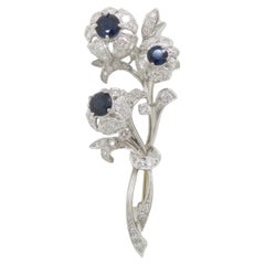 Broche vintage de platino con diamantes y zafiro azul