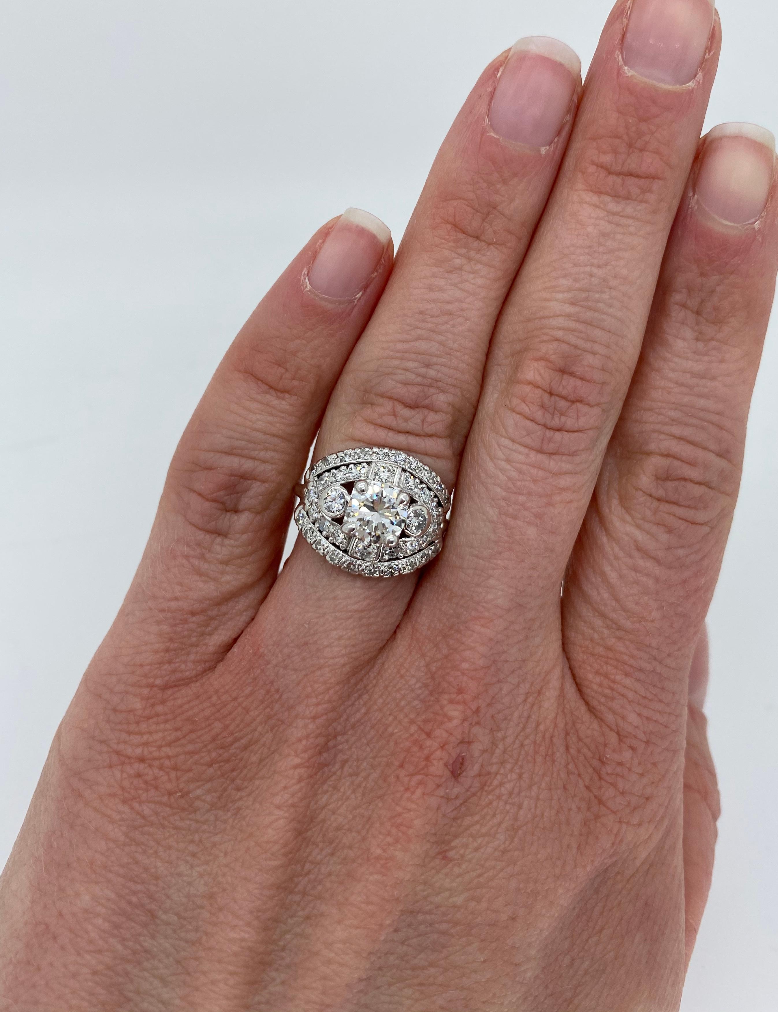 Unique 1.80CTW vintage diamond ring crafted in platinum.

Center Diamond Carat Weight: Approximately 1.00CT
Center Diamond Cut: Round Brilliant 
Center Diamond Color: J-K
Center Diamond Clarity:  VS2
Total Diamond Carat Weight: Approximately