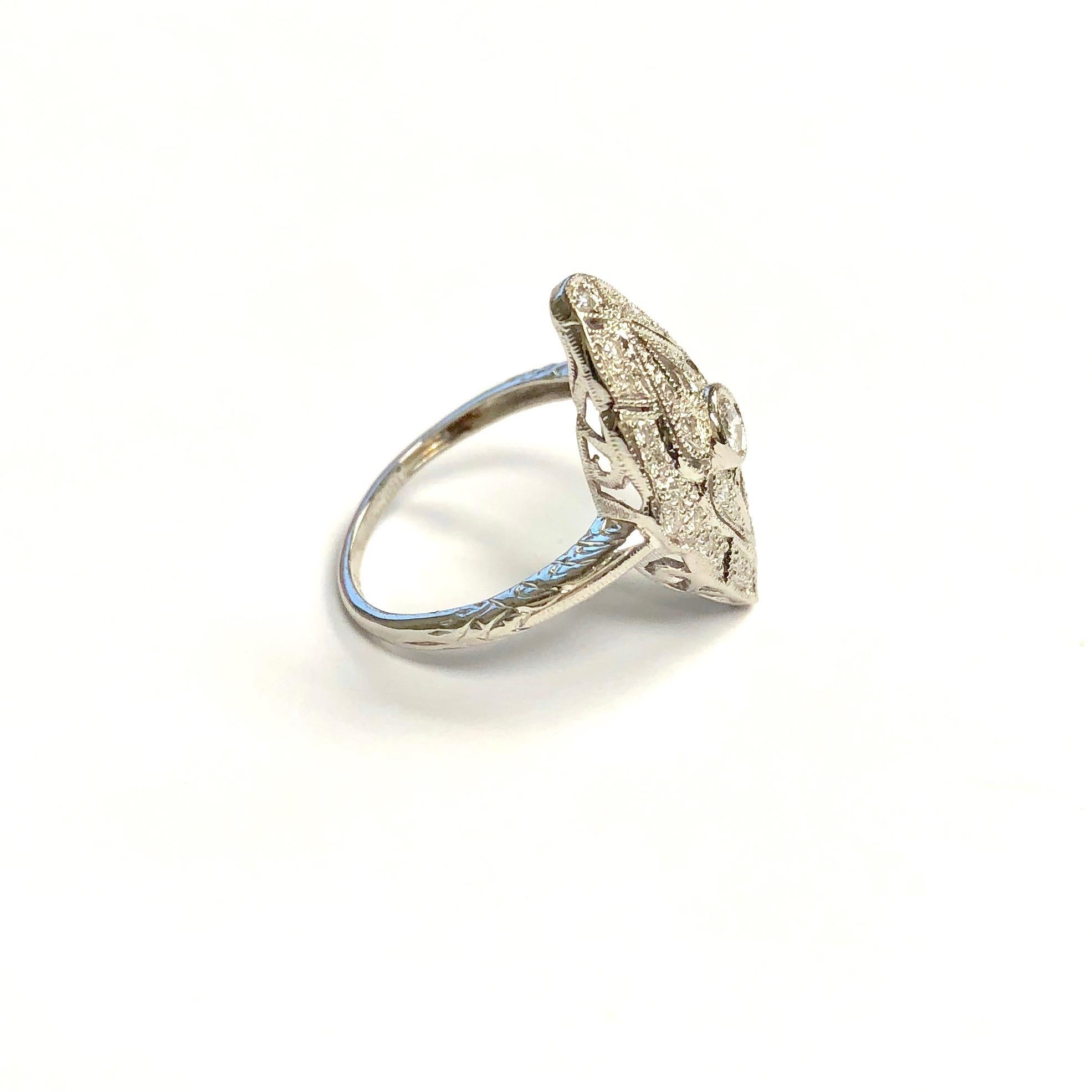 Classic platinum and diamond ring, featuring a navette shaped open-work design with milgrain edges, supported by hand engraved shoulders and a one and a half millimeter wide band. Forty-one round brilliant cut diamonds with 0.36 carat total weight
