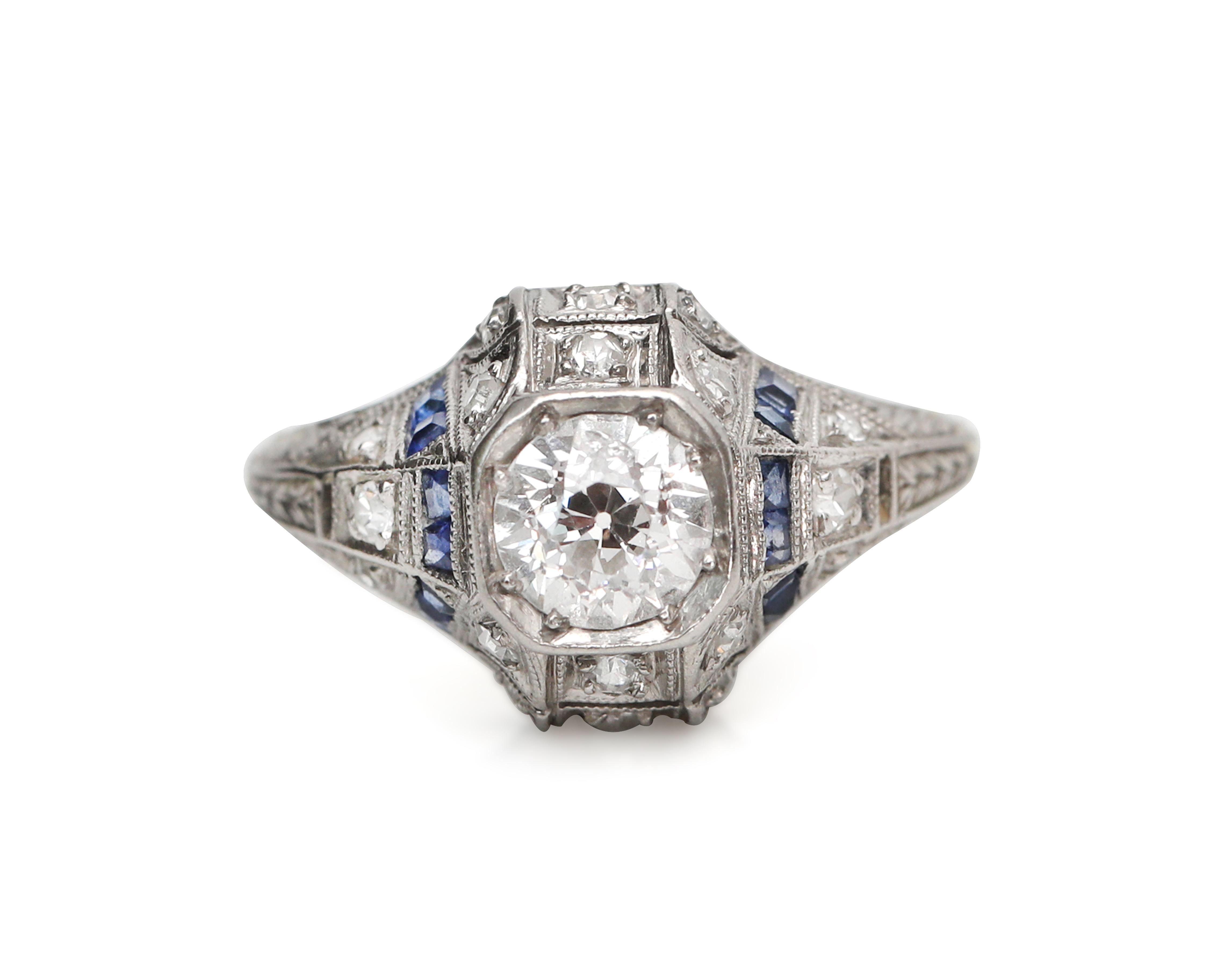 This fine example of Art Deco style is crafted in platinum with sapphire accents highlighting the stunning solitaire. The brilliant center diamond is approximately 0.76 carats and the correct Old European cut for the time period. The ring still
