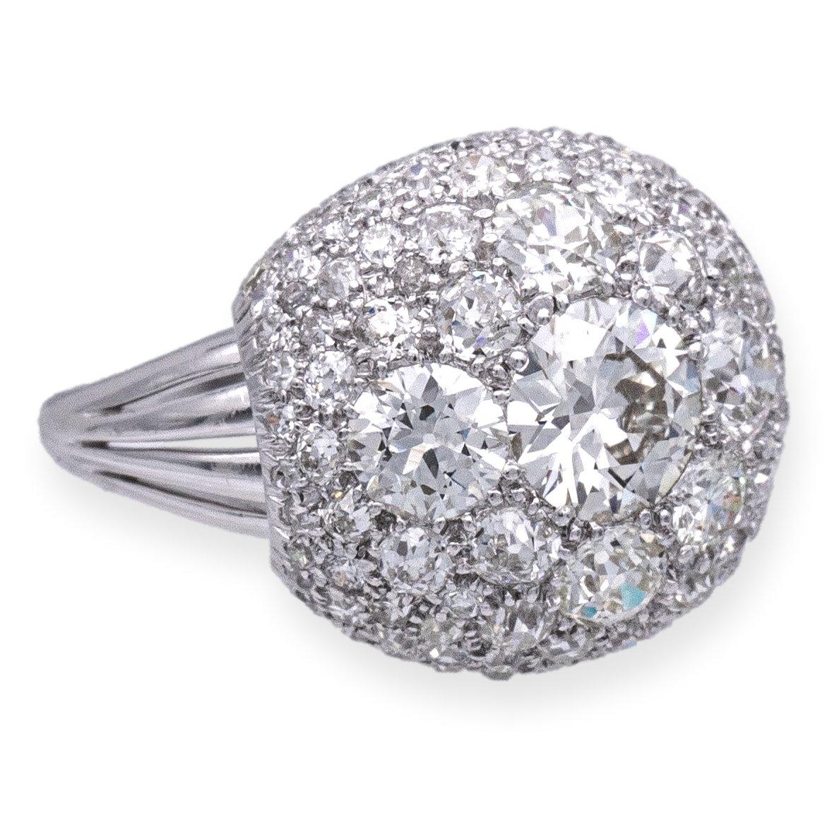 Exquisite vintage cocktail ring, meticulously crafted in platinum. Its distinctive dome cluster design showcases a harmonious fusion of old European cut diamonds, round cut and single cut diamonds, boasting a remarkable total weight of 5.11 carats.