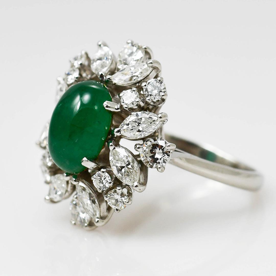Ladies Platinum Vintage Emerald & Diamond Ring
Stamped platinum and weighs 10.7 grams.
The center stone is a natural Colombian emerald, cabochon cut, approximately 2 carats, deep rich green color.
On the sides are marquise shape and round brilliant