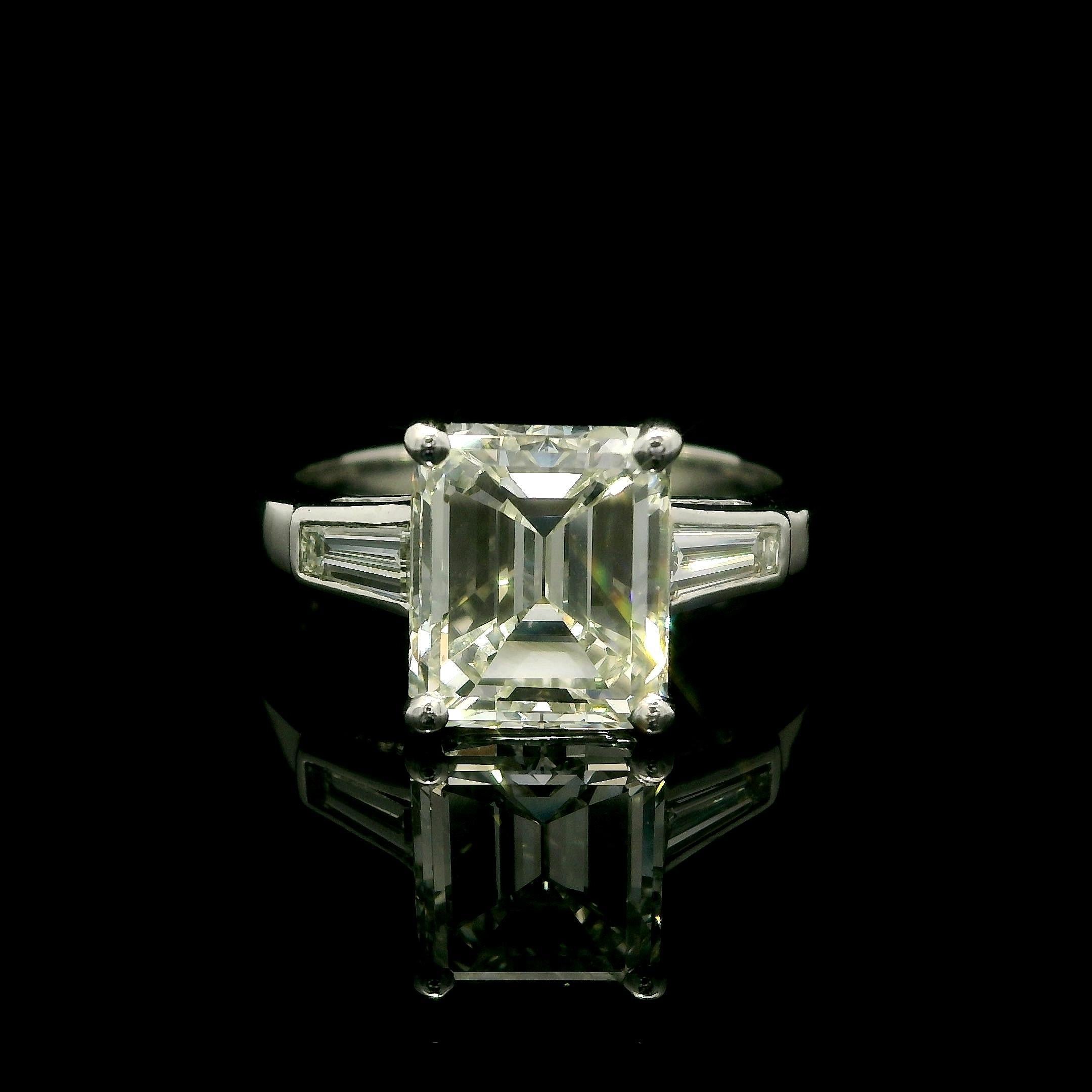 --Stone(s):--
(1) Natural Genuine Diamond - Old Emerald Cut - Prong Set- J Color - VVS2 Clarity - 2.57ct (exact - certified)
** See Certification Details Below for Complete Info **
(2) Natural Genuine Diamonds - Tapered Baguette Cut - Channel Set -