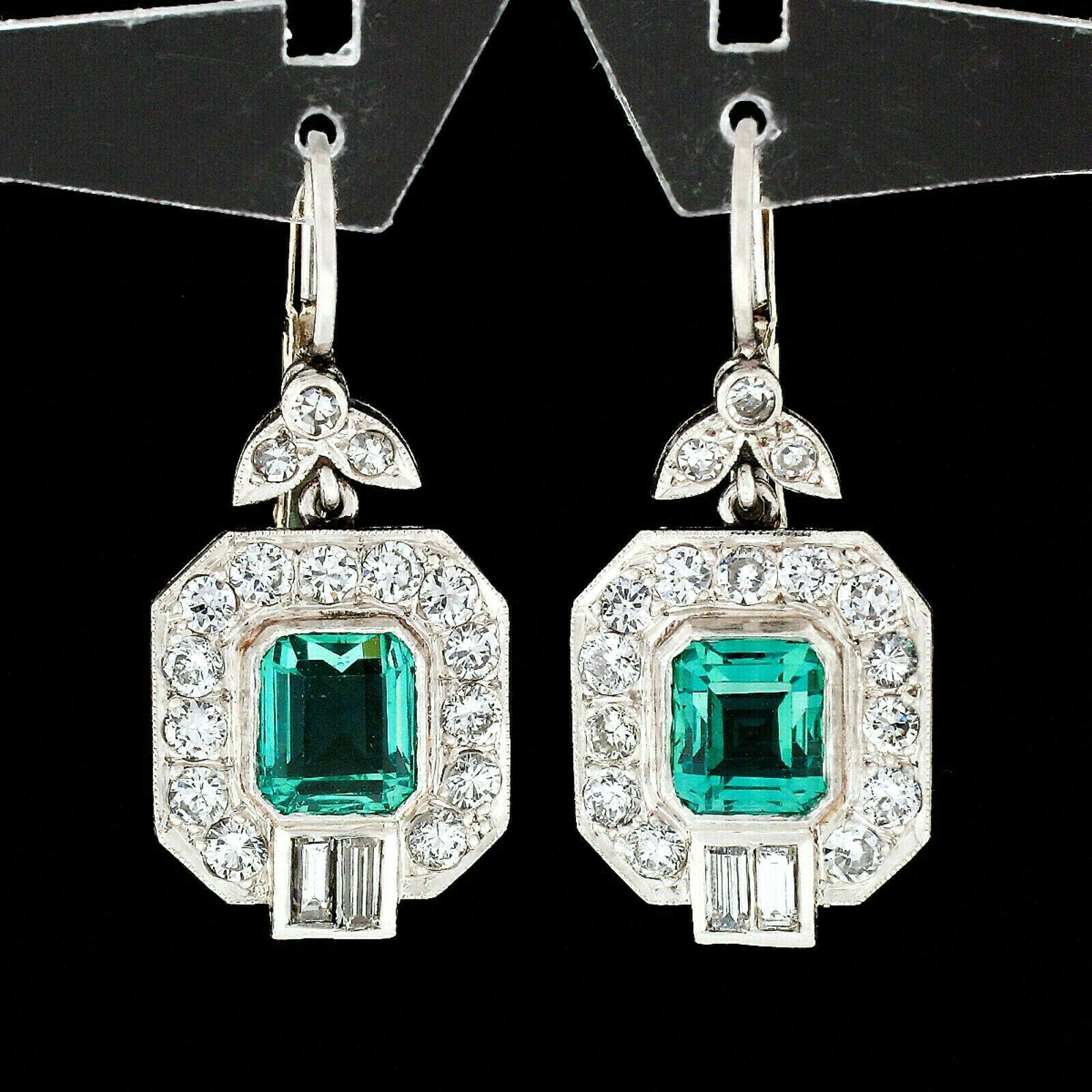 This magnificent and fancy pair of emerald and diamond earrings is crafted in solid platinum and features two gorgeous, Colombian green emeralds that have been certified by GIA. The emeralds weigh approximately 2.80 carats in weight. They display