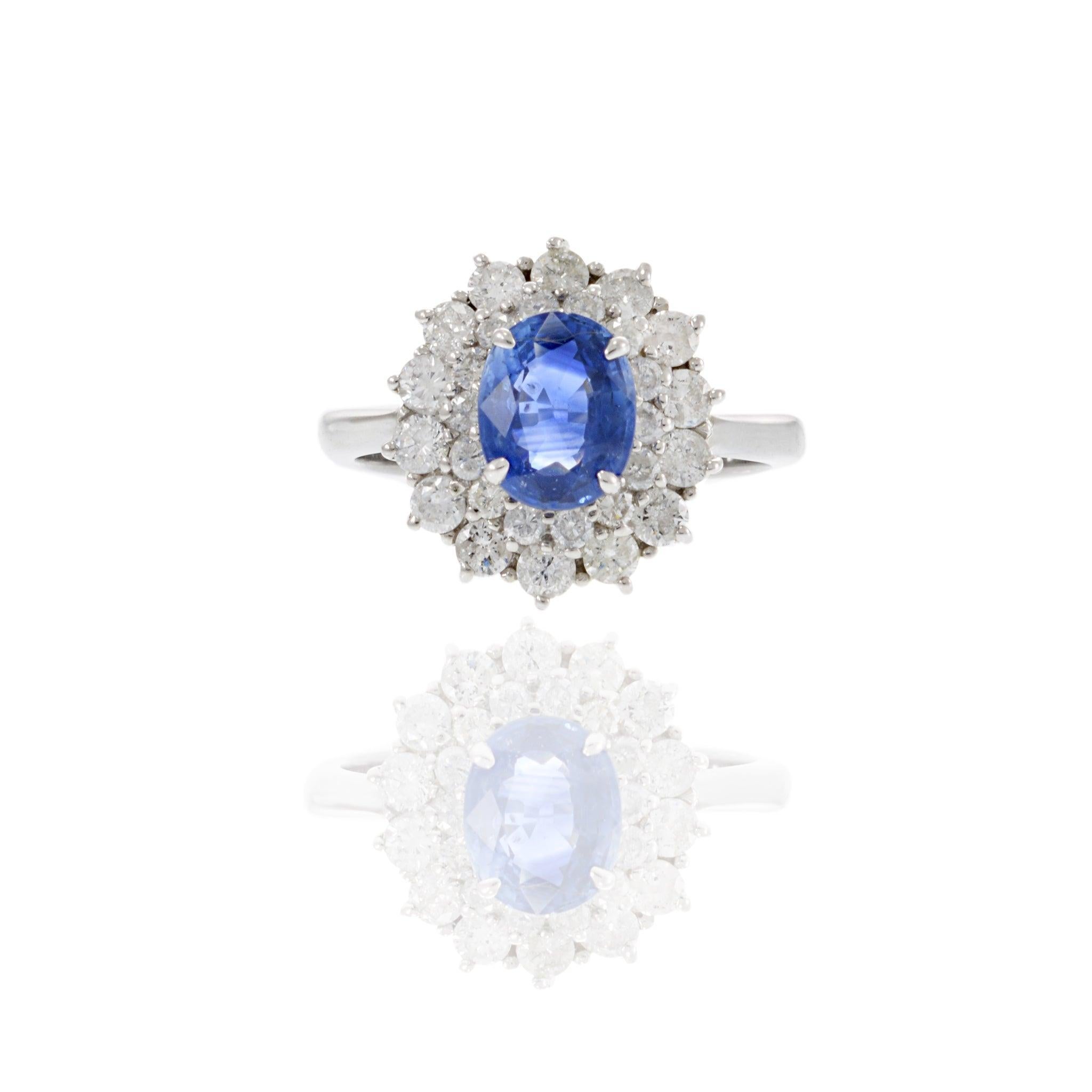 Dieser Platin-Cocktailring ist eine schillernde Hommage an den klassischen Glamour. Der blaue Saphir im Ovalschliff von 1,46 Karat in der Mitte des Schmuckstücks wird elegant von einem Halo aus runden Diamanten im Brillantschliff mit einem
