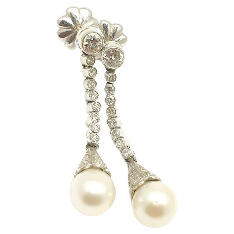 Vintage platinum dangling earrings with old mine cut diamonds estimate weight of 1.5 cararts with 2 white natural pearls with total lenght 7cm