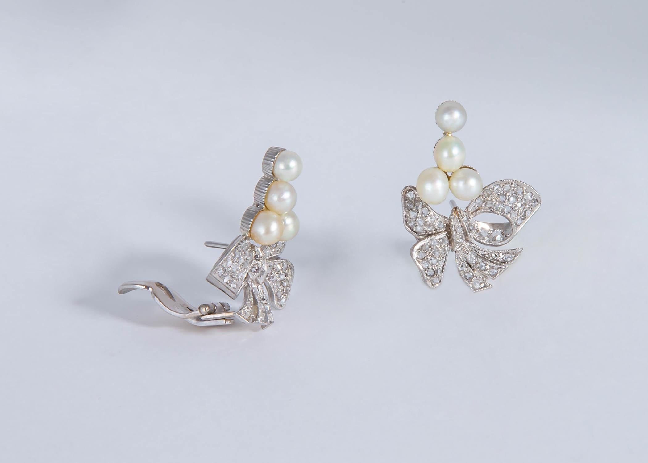 This is simply an amazing example of Mid-Century style and design. Bow motif mountings are crafted out of pure platinum and set with soft white pearls. Rose cut diamonds finish this outstanding pair of wearable chic earrings. 1 inch in length.