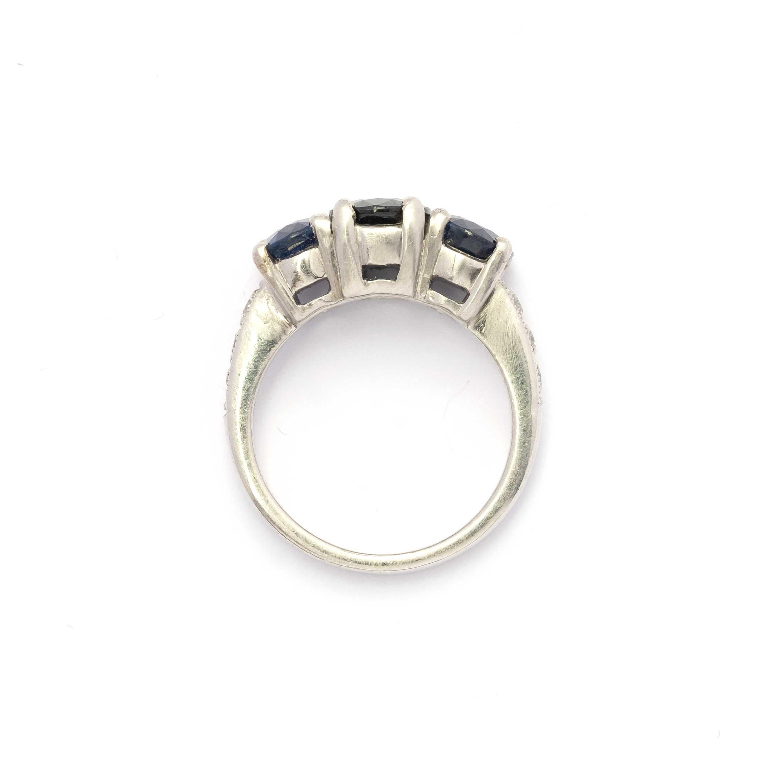 Gioiello di rara eleganza e fascino senza tempo, questo anello vintage in platino 950 mette in mostra una splendida trilogia di zaffiri naturali, con un peso totale di circa 2,50 carati, splendidamente completata da diamanti a taglio brillante per