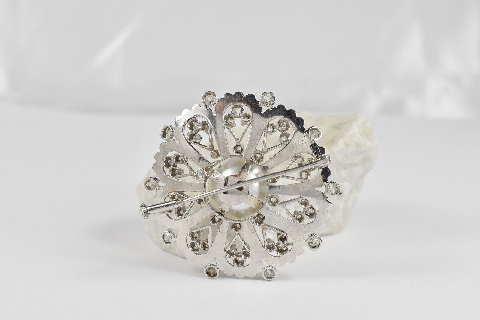 This exquisite vintage brooch is crafted in platinum and features a striking floral-inspired design centered around a 15.37mm round cultured saltwater pearl. Radiating outward from the pearl, the brooch is adorned with a combination of rose-cut and