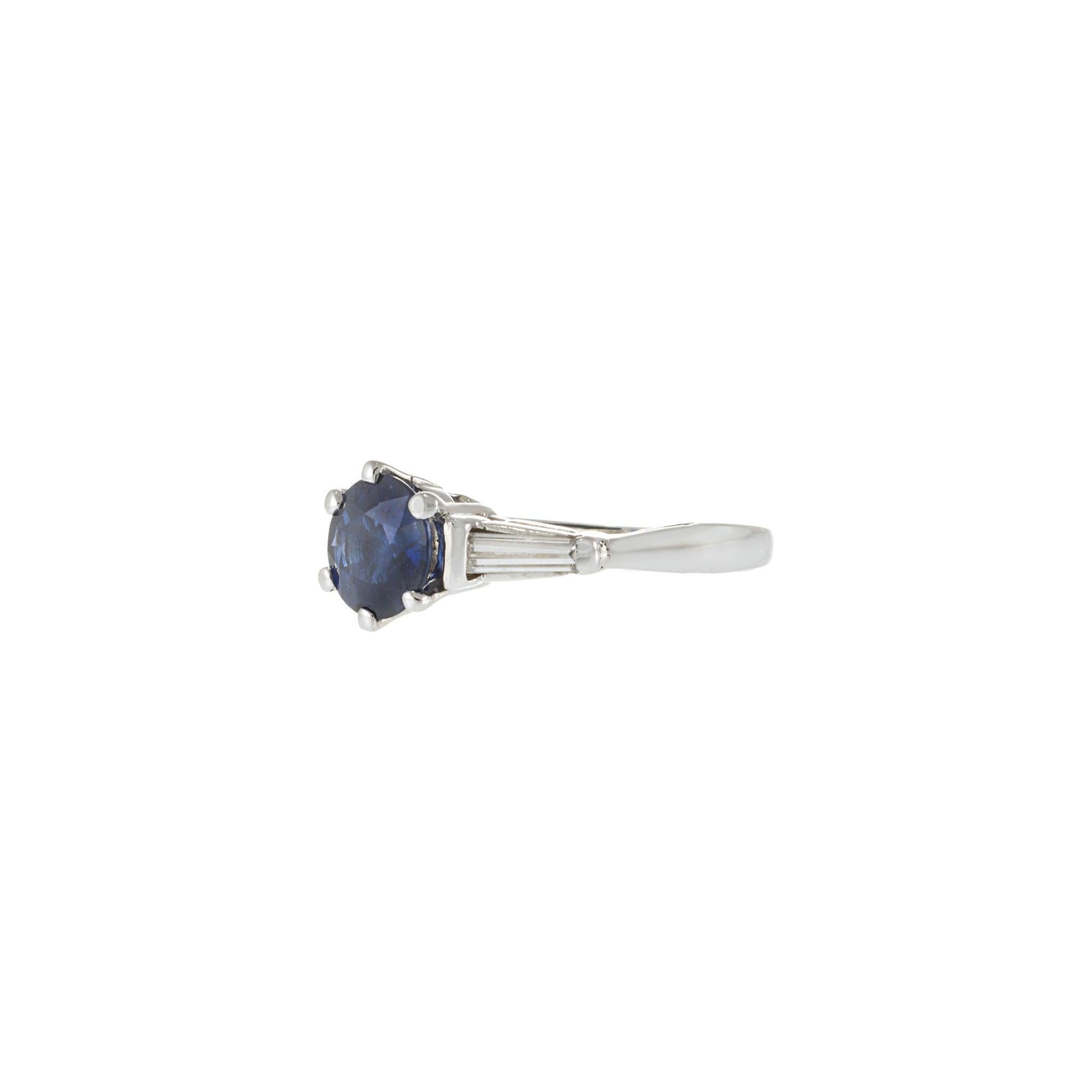 Impresionante tesoro de los años 50, este anillo de herencia vintage captura la elegancia de mediados de siglo en su forma más pura. Realizado a mano en platino, el diseño exhibe un cautivador zafiro azul de talla redonda de 1,55 quilates,