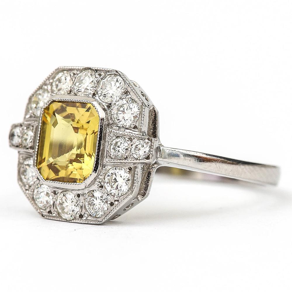 A lovely vintage mid-century platinum, yellow sapphire and diamond cluster ring. The emerald cut yellow sapphire is estimated at 1.50ct, the brilliant cut diamonds surrounding the sapphire are estimated at 1.00ct in total. All the gems are