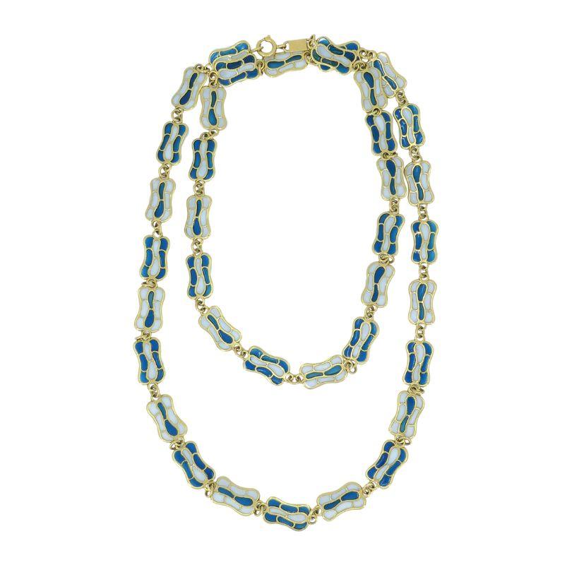 Ce collier vintage des années 1970 est un exemple frappant de savoir-faire et de design, utilisant la technique de l'émail plique-à-jour pour créer un effet lumineux de vitrail. Réalisé en or 18 carats, le collier présente des segments reliés entre