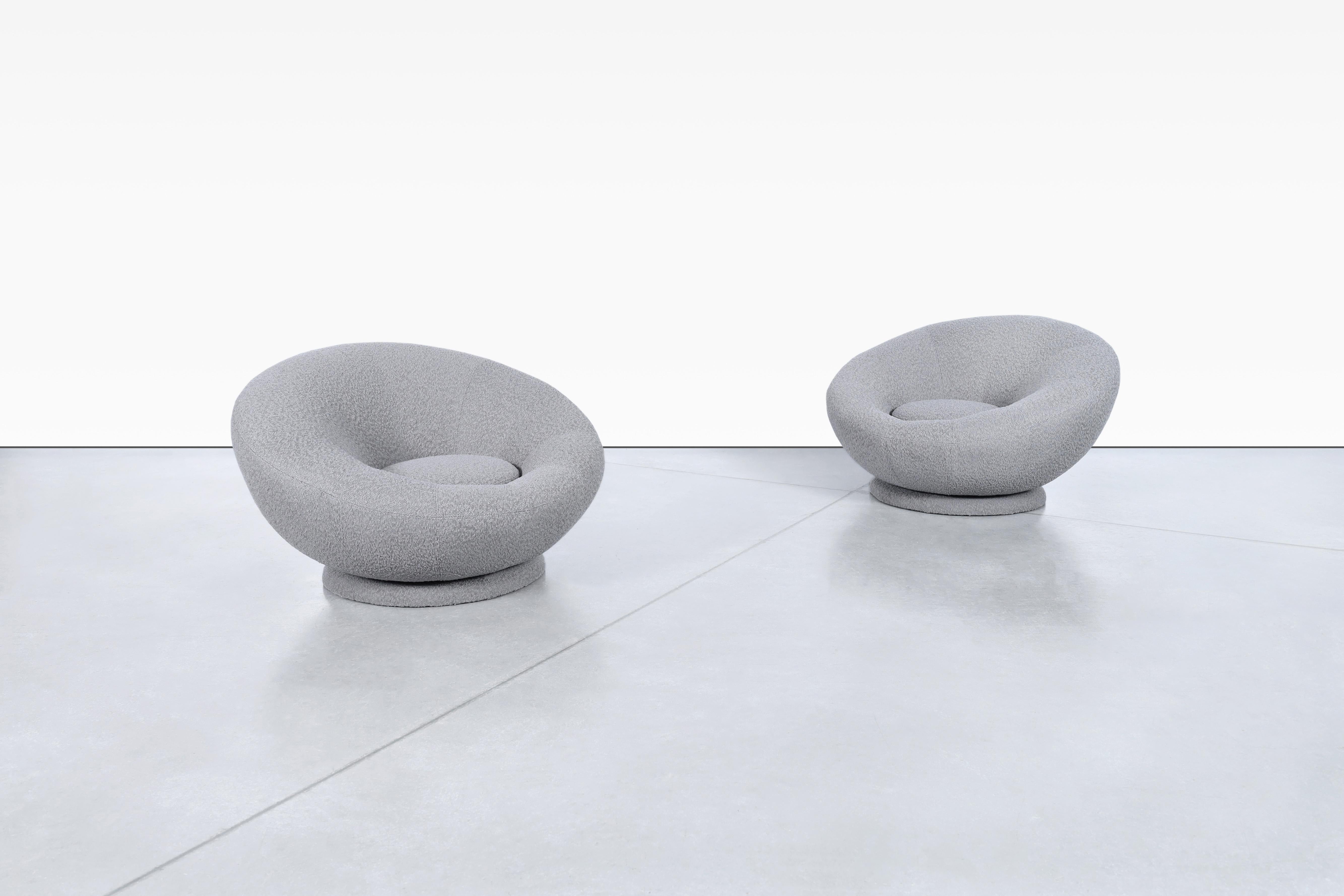 Transport yourself back to the 1980s with these stunning vintage swivel lounge chairs. These distinctive chairs showcase a sleek and unique pod-shaped design, exuding a timeless appeal. Recently reupholstered in a luxurious gray boucle fabric, these