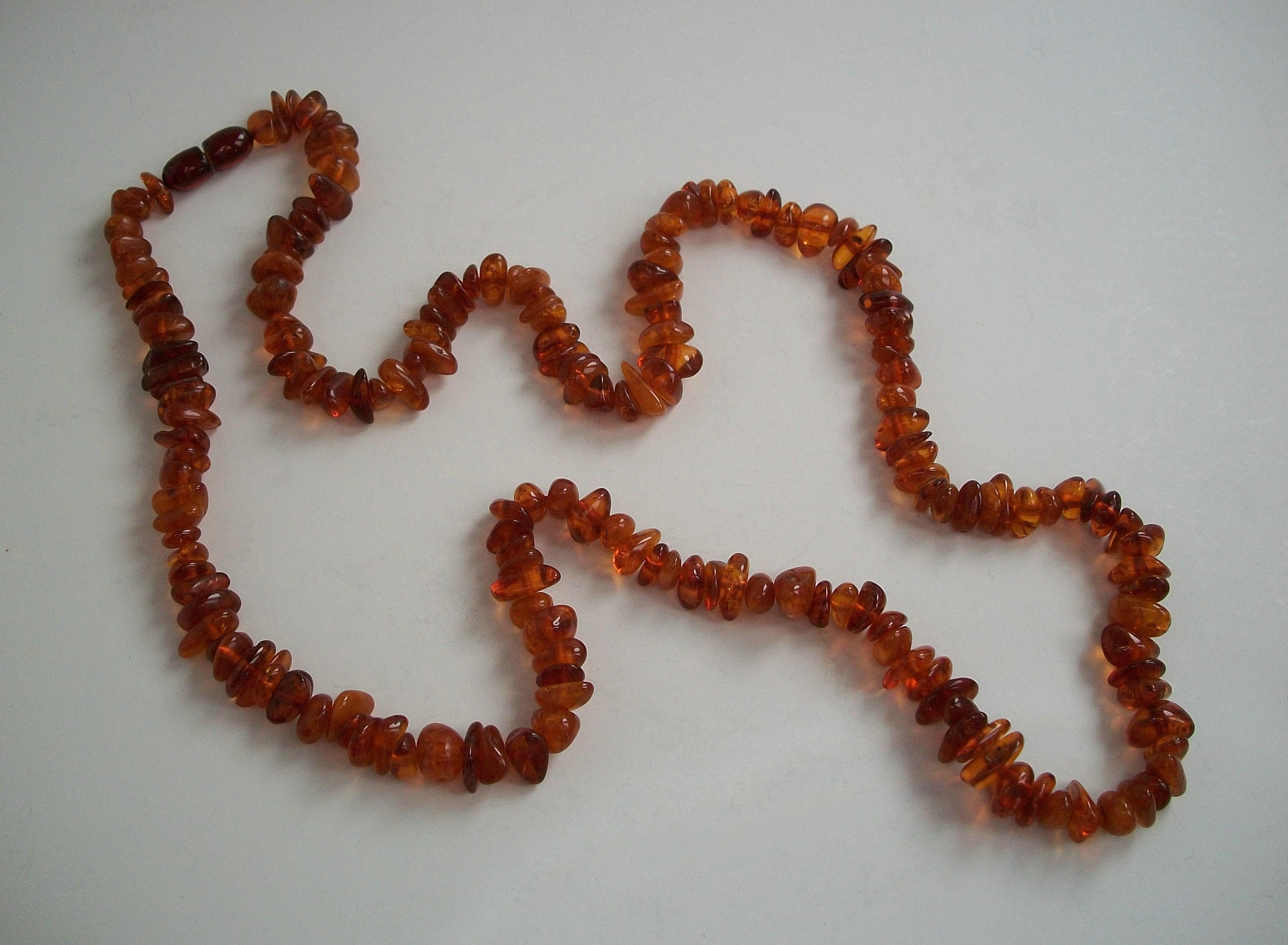 Sautoir vintage en ambre baltique - perles polies (certaines avec des inclusions) - peut être doublé pour être porté en tour de cou - fermoir original en forme de barillet - circa 1930.

Excellent état vintage - tout d'origine - pas de perte - pas