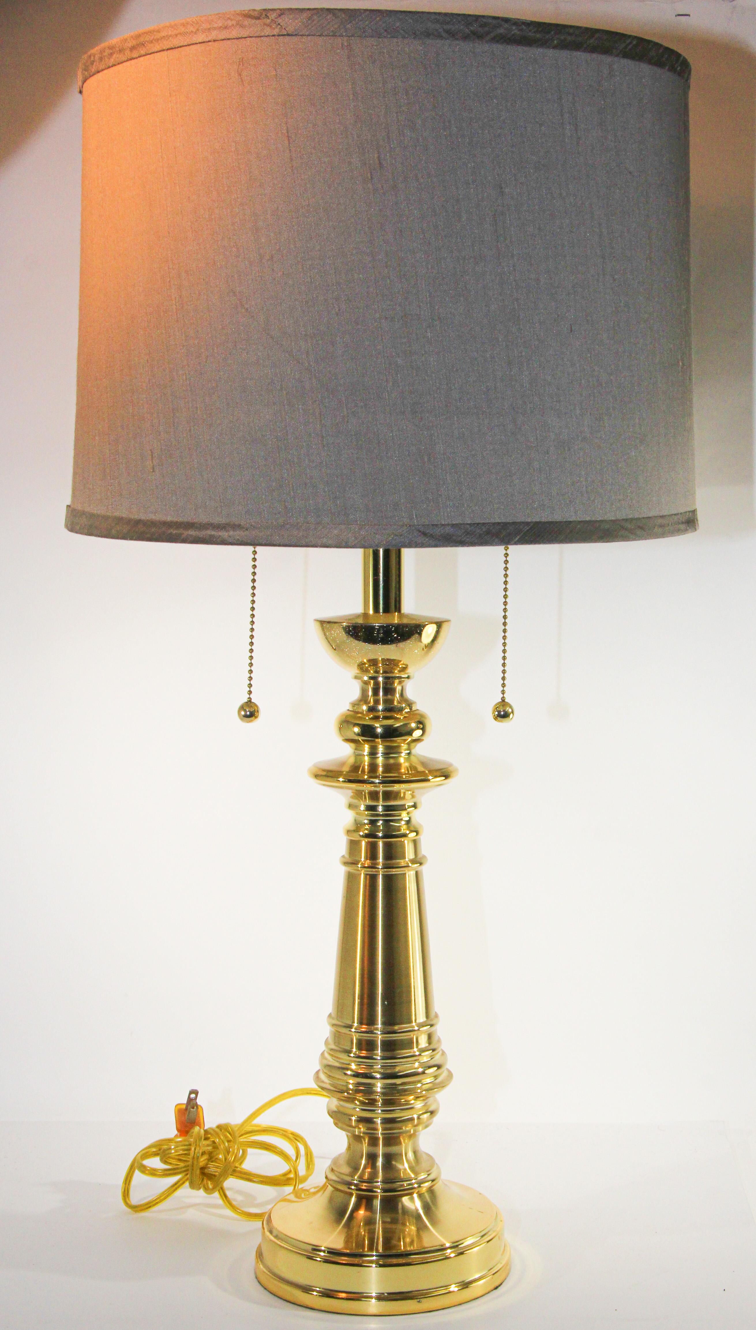Vintage polished brass turned column table lamp.
Hollywood Regency style turned column form table lamp.
Crafted of solid cast brass, this elegant table lamp has a polished brass finish. 
On-off switch on double sockets. 
Traditional solid brass