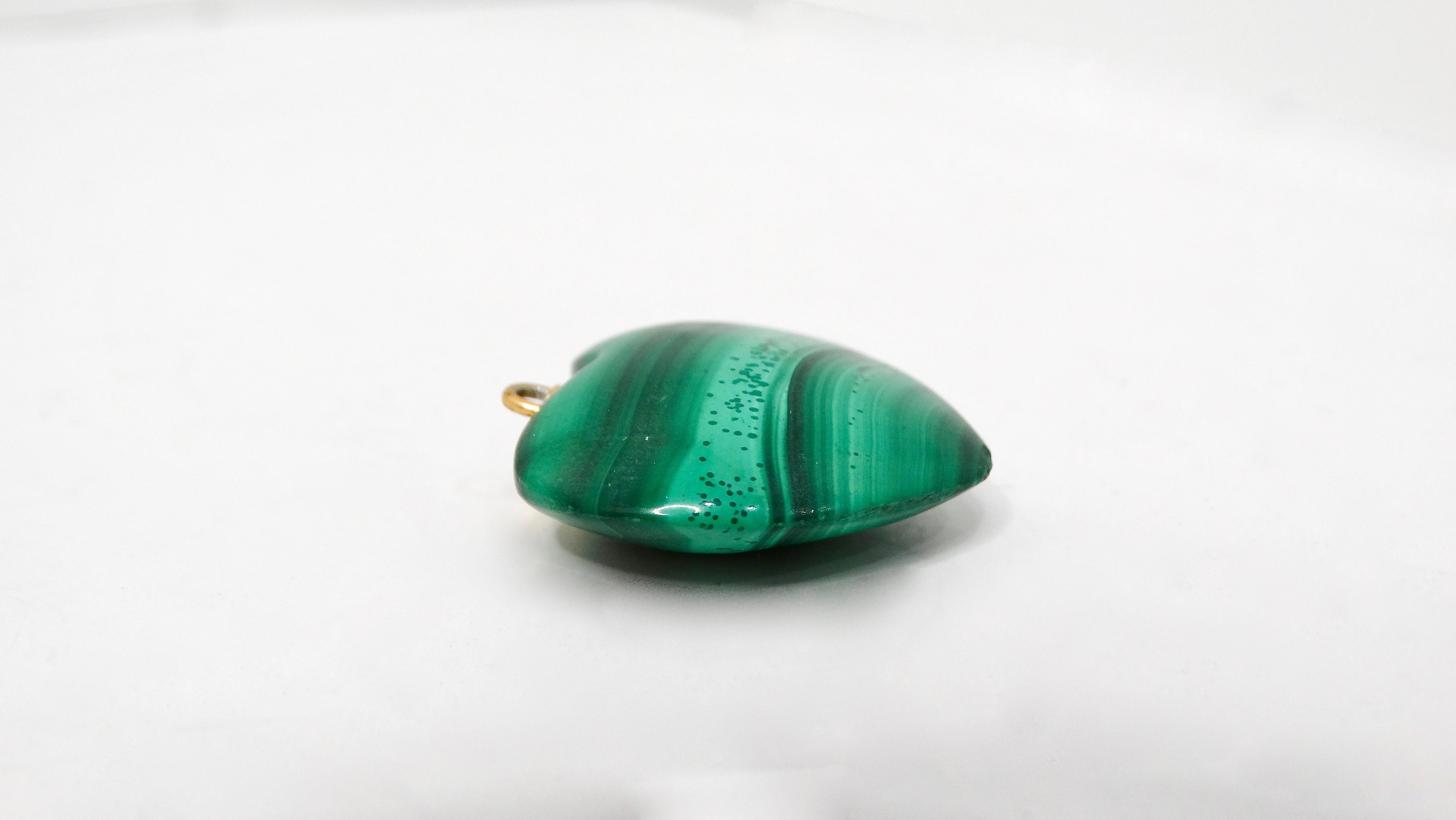Scopri il fascino incantevole del Ciondolo a cuore in malachite lucida vintage, un pezzo incantevole che cattura magnificamente l'essenza unica di questa splendida pietra preziosa. Rinomata per le sue ricche sfumature verdi e i suoi vortici