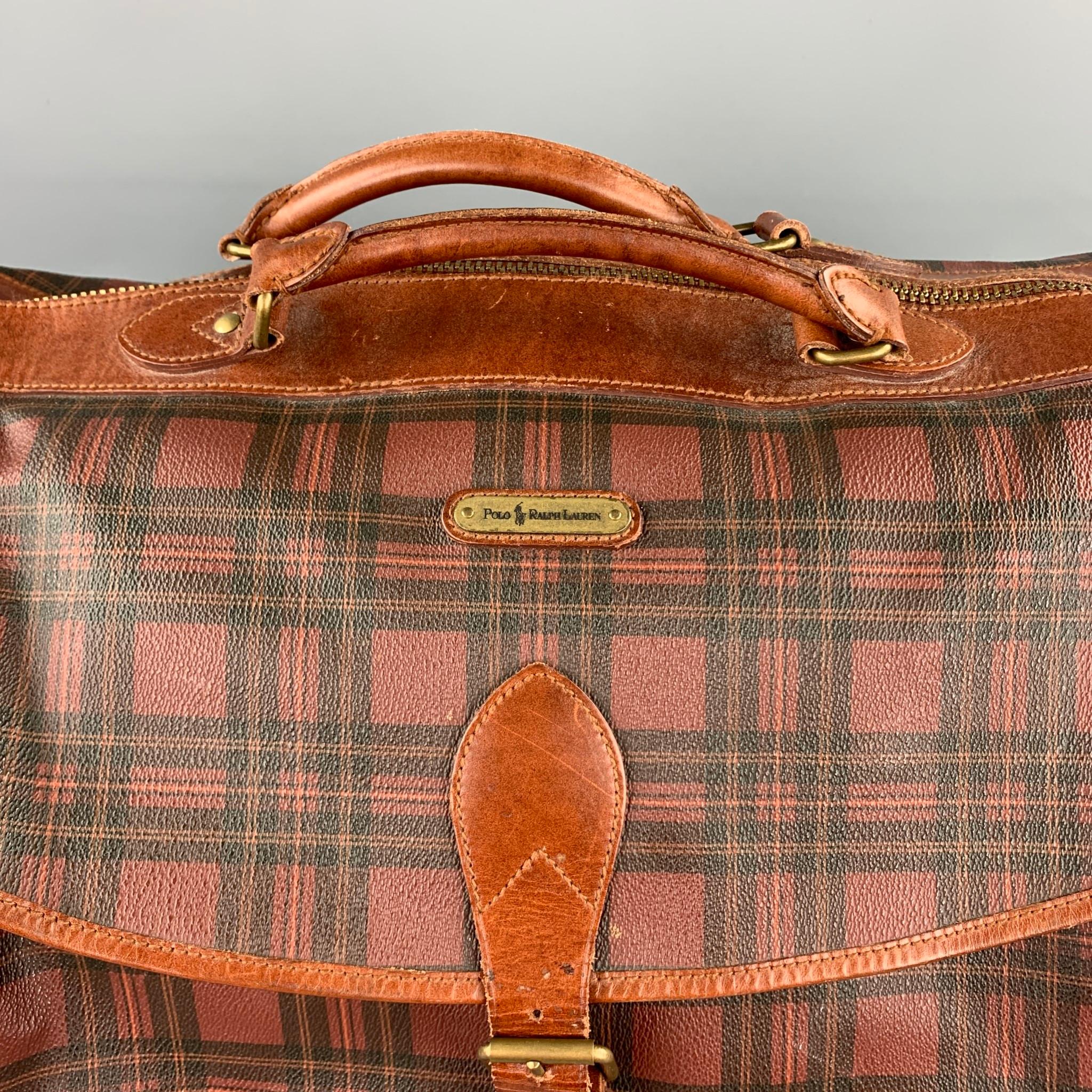 Vintage POLO by RALPH LAUREN bag comes in a brown & black plaid coated canvas featuring a travel style, shoulder strap, front pocket, and a zip up closure.

Good Pre-Owned Condition.

Measurements:

Length: 21 in.
Width: 10 in.
Height: 12 in.
Drop: