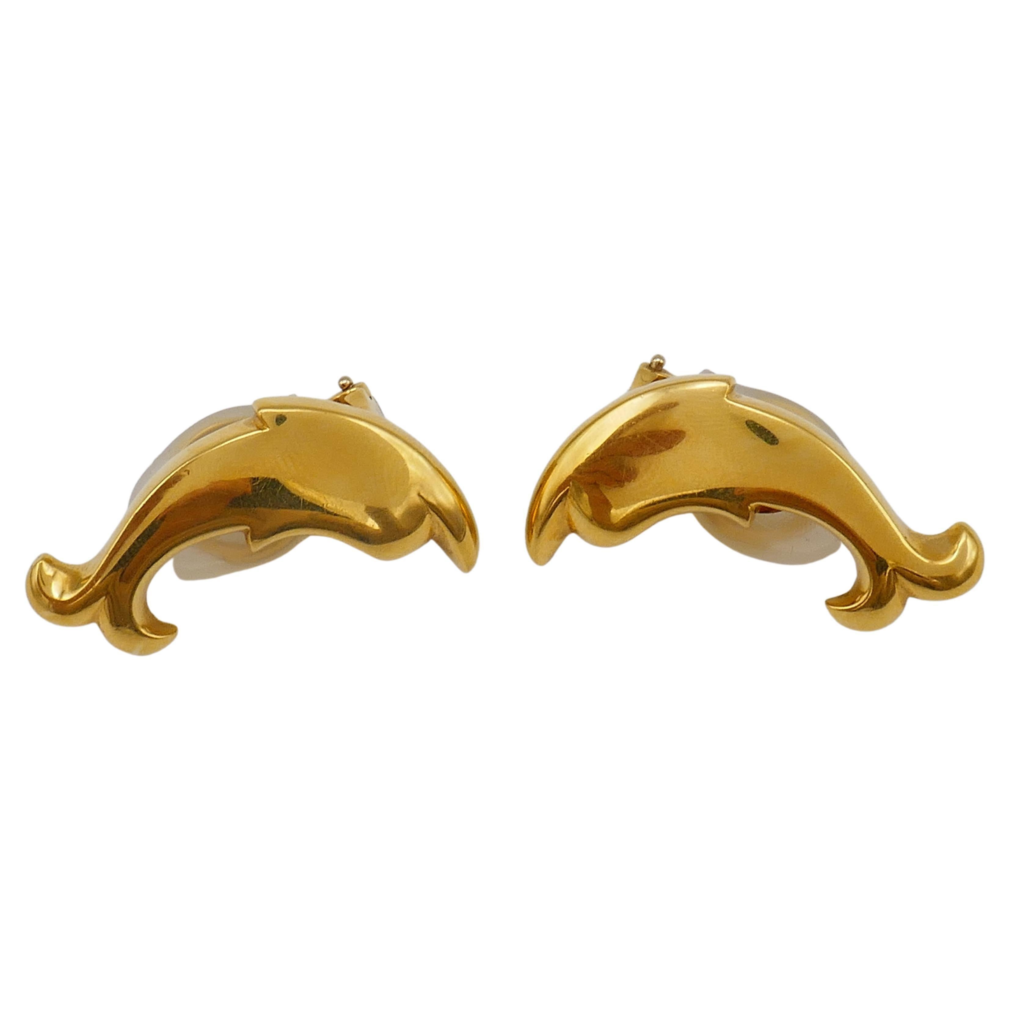 Am amazing vintage Pomellato set consists of a gold brooch and a pair of earrings designed as  swimming dolphin silhouettes. 
Crafted of 18k yellow gold with high-polished finish. 
The earrings are clip-ons, posts can be added.
In jewelry dolphins