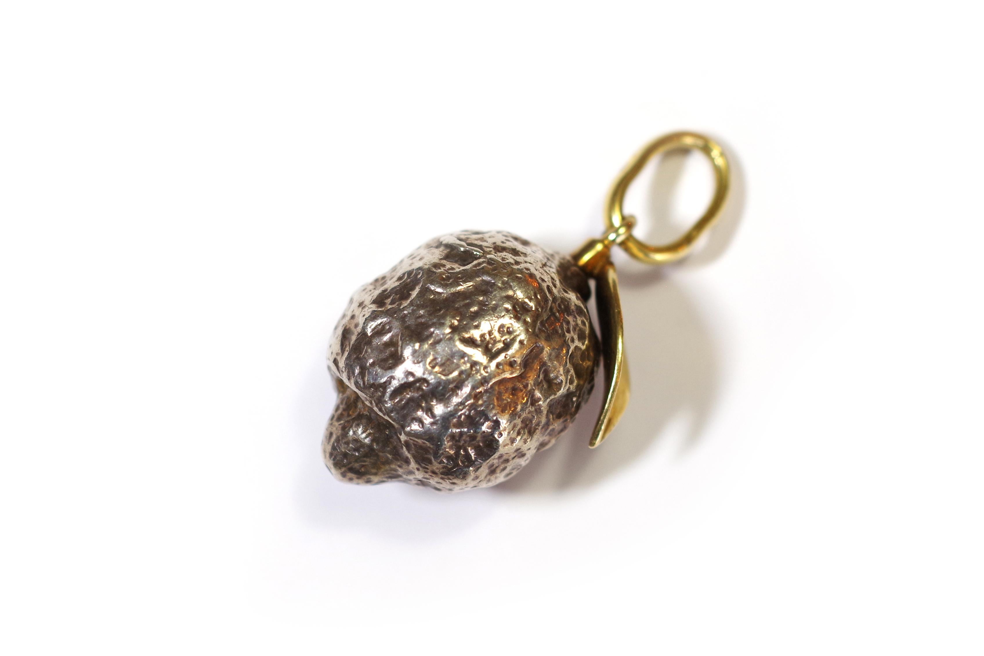 Vintage Pomellato lemon pendant in 18 karat gold and silver. Important naturalist pendant representing a lemon. The pendant is made entirely of silver with a gold leaf attached to the fruit. Vintage jewel from the early years of the Italian brand