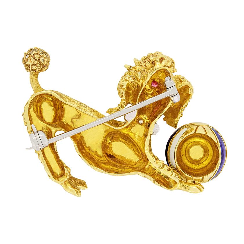 This whimsical vintage brooch features a playful poodle with a ball. Crafted from 18 carat yellow gold the piece is beautifully crafted, with 0.02 carat rubies used for the dogs eyes. Along it’s platinum collar, a series of three 0.01 carat eight