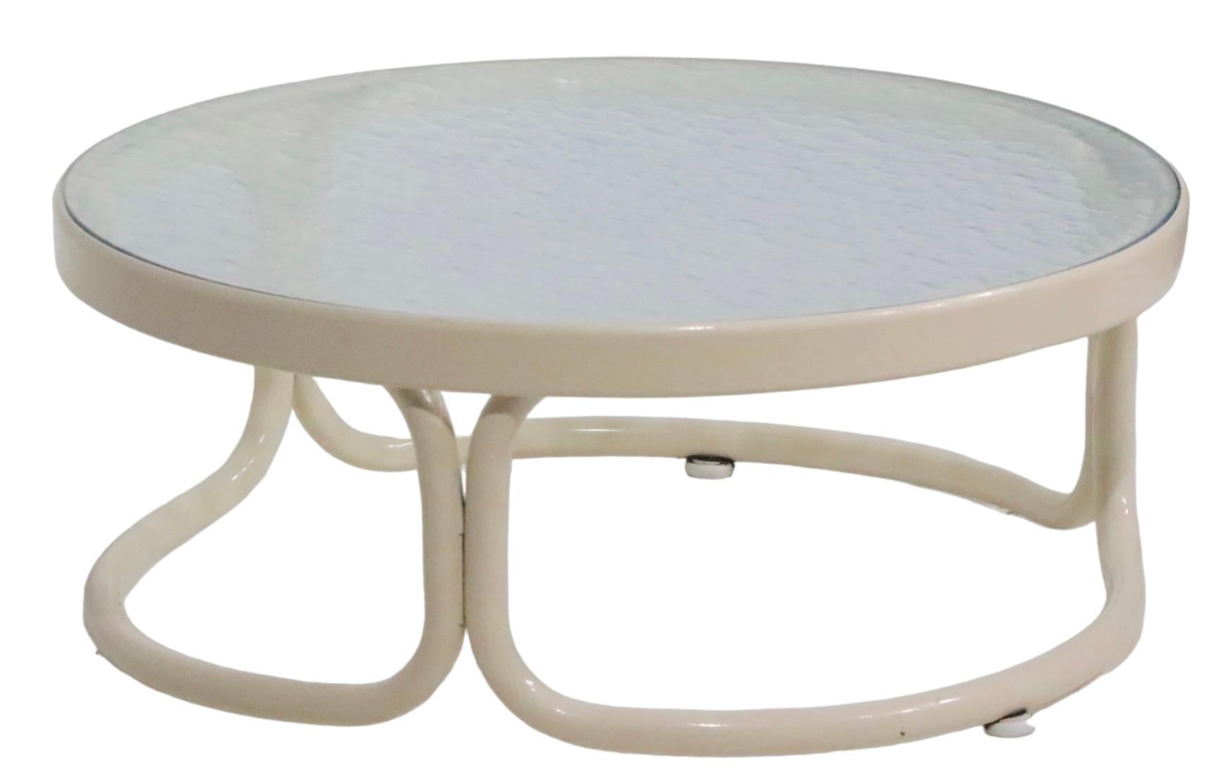 Stylish, chic, and voguish vintage patio,  poolside garden side table, having a tubular aluminum frame, with a textured glass top. The table is in excellent original clean and ready to use condition, showing only light cosmetic wear, normal and
