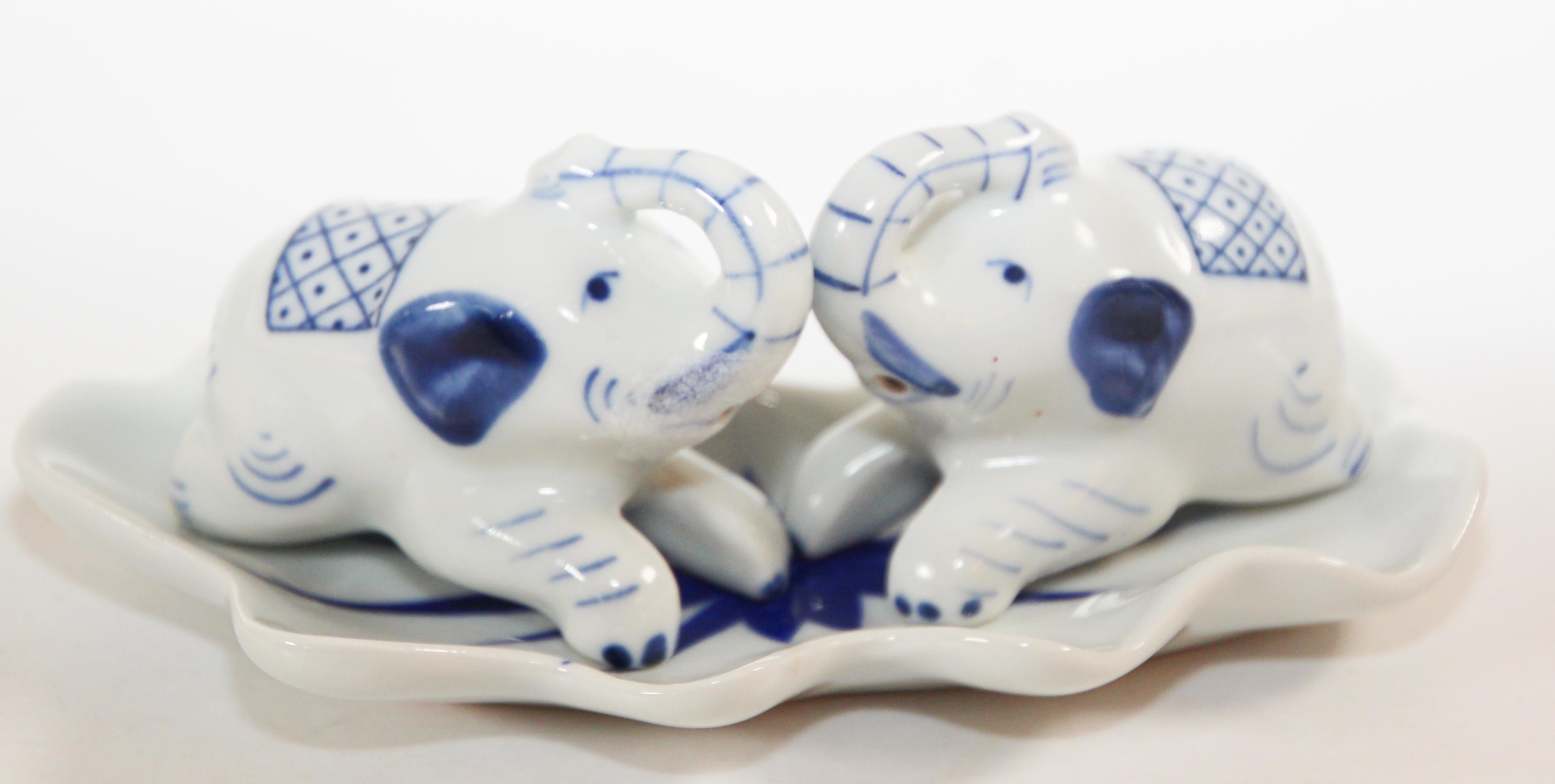 Vintage collectible blue and white porcelain elephants salt and pepper Shakers with tray.
Shakers are 2”H x 2 1/5”. 
Tray is 3” x 5”. 
Chinoiserie hand painted porcelain of elephants, trunk up for good luck.