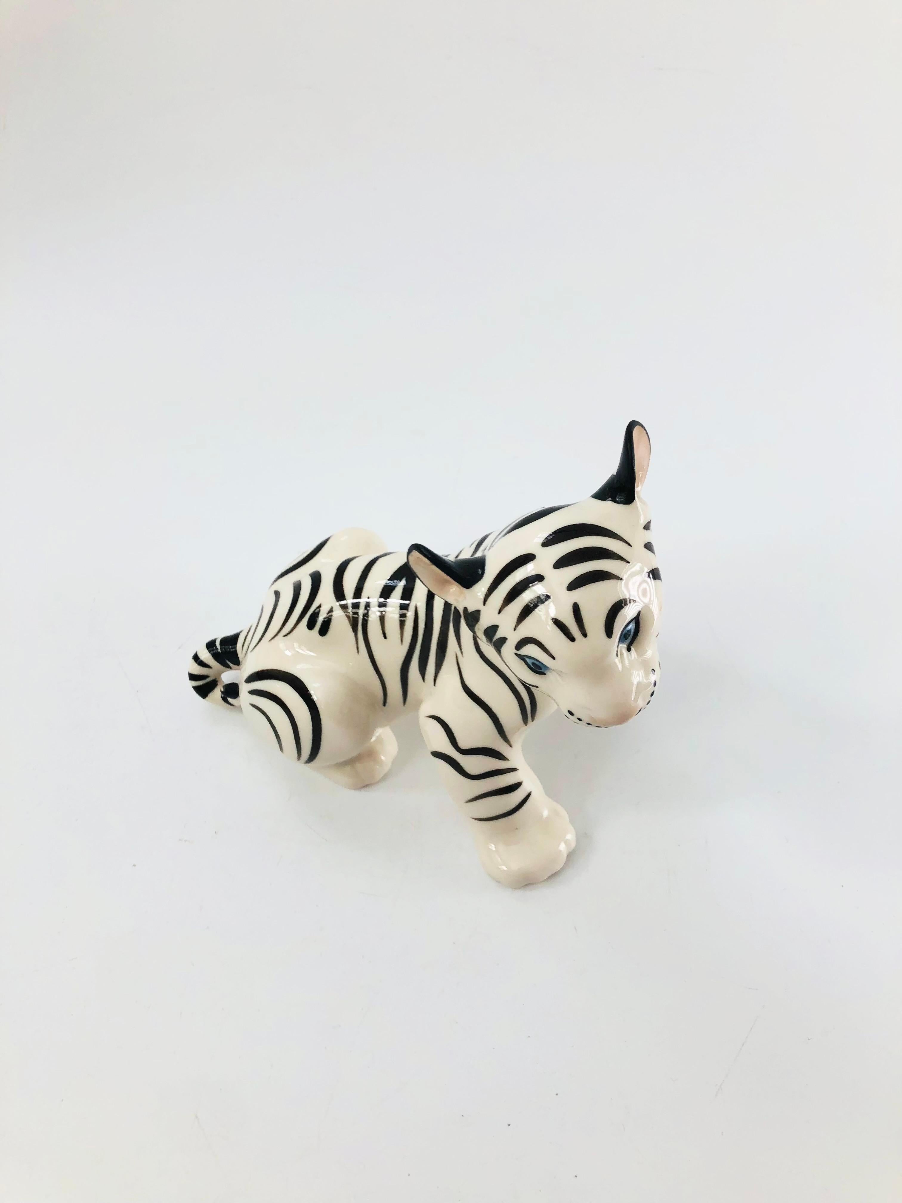 A vintage porcelain figurine of a white tiger by Lomonosov. Made in Russia. Lovely details with blue eyes and painted black stripes. Marked on the base with the blue Lomonosov mark.


