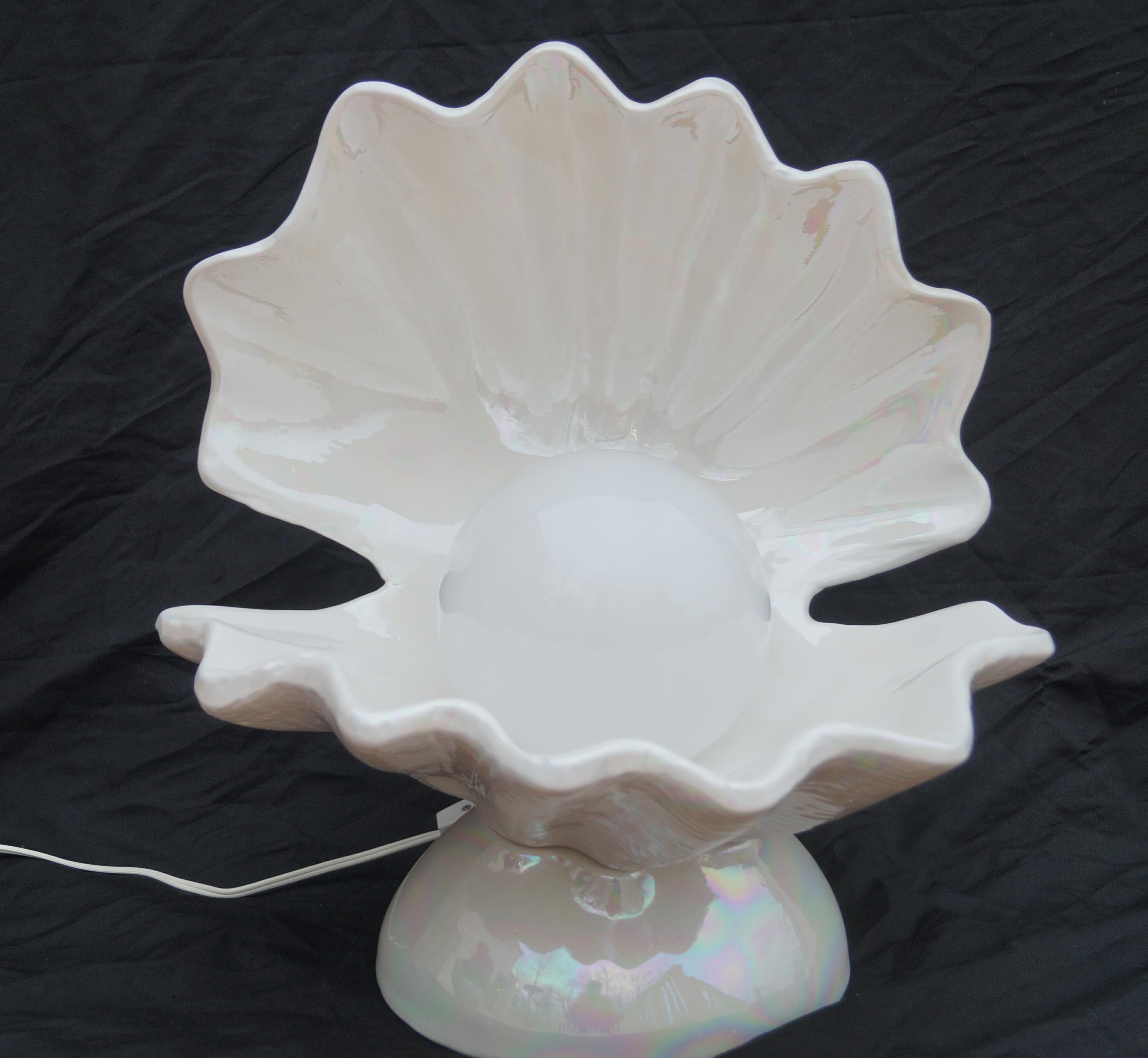 Vintage clam shell shaped lamp with an interior light covered with globe. Opalascent colors are within.
   