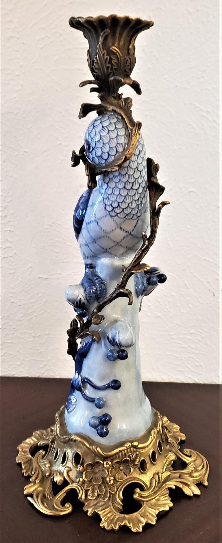 The candelabra or candlestick is made of bronze ormolu wrapped around a hand painted blue and white porcelain parrot.

Holds a single candle.

Very French Art Nouveau in style but we are of the belief that this was most likely made in China in
