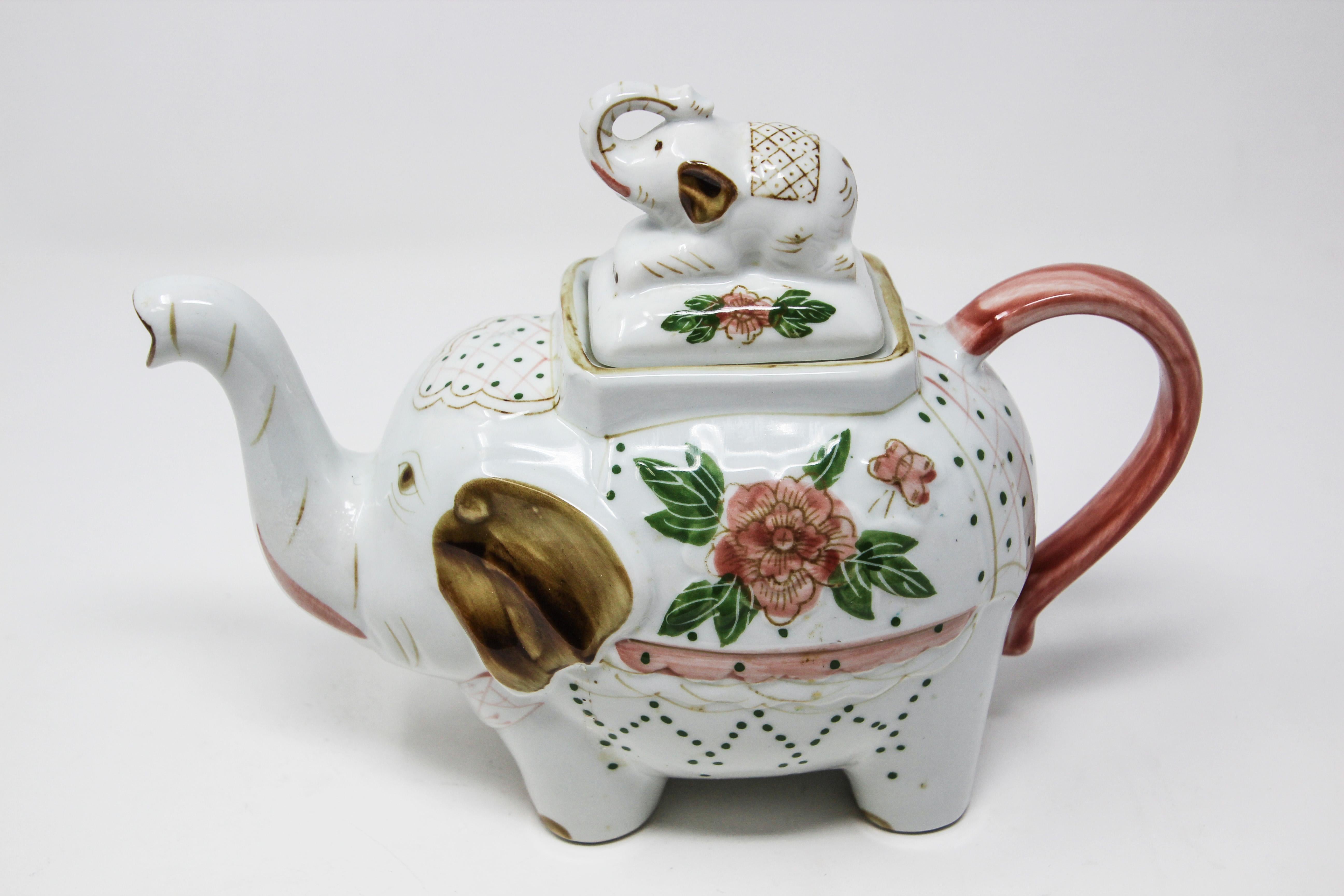 Vintage Victorian style porcelain teapot in the form of an elephant carrying a baby elephant.
Vintage elephant tea pot with beautiful Victorian style flower design.
This wonderful oriental ceramic tea pot is modeled as a standing elephant carrying