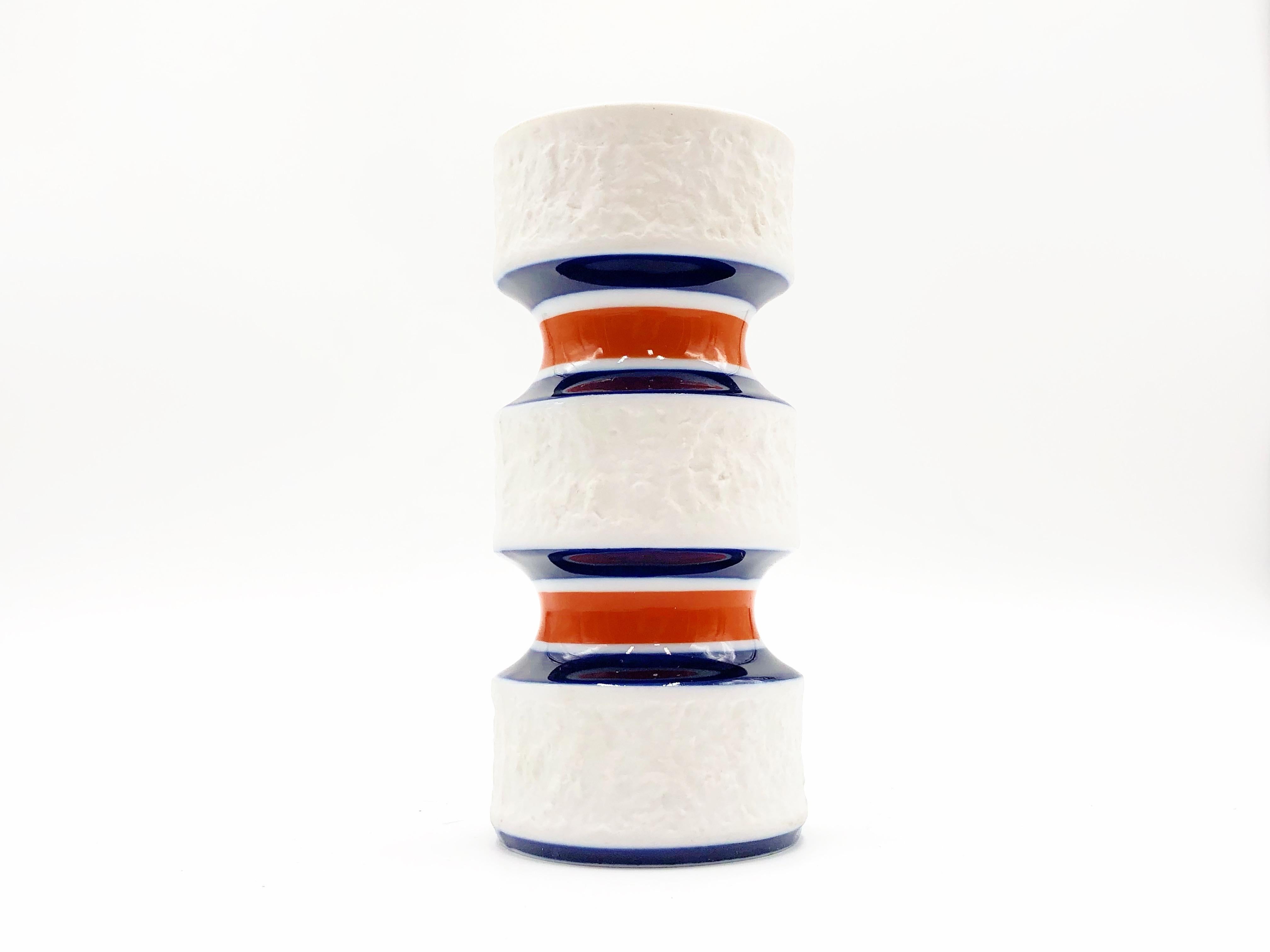 Mid-Century Modern porcelain vase by KPM Royal Porcelain Factory in Germany, circa 1960s.

White matte bisque unglazed textured porcelain vase with orange and navy glazed accent. Interior is glazed. Marked KPM on base.

Details:
- 6.1