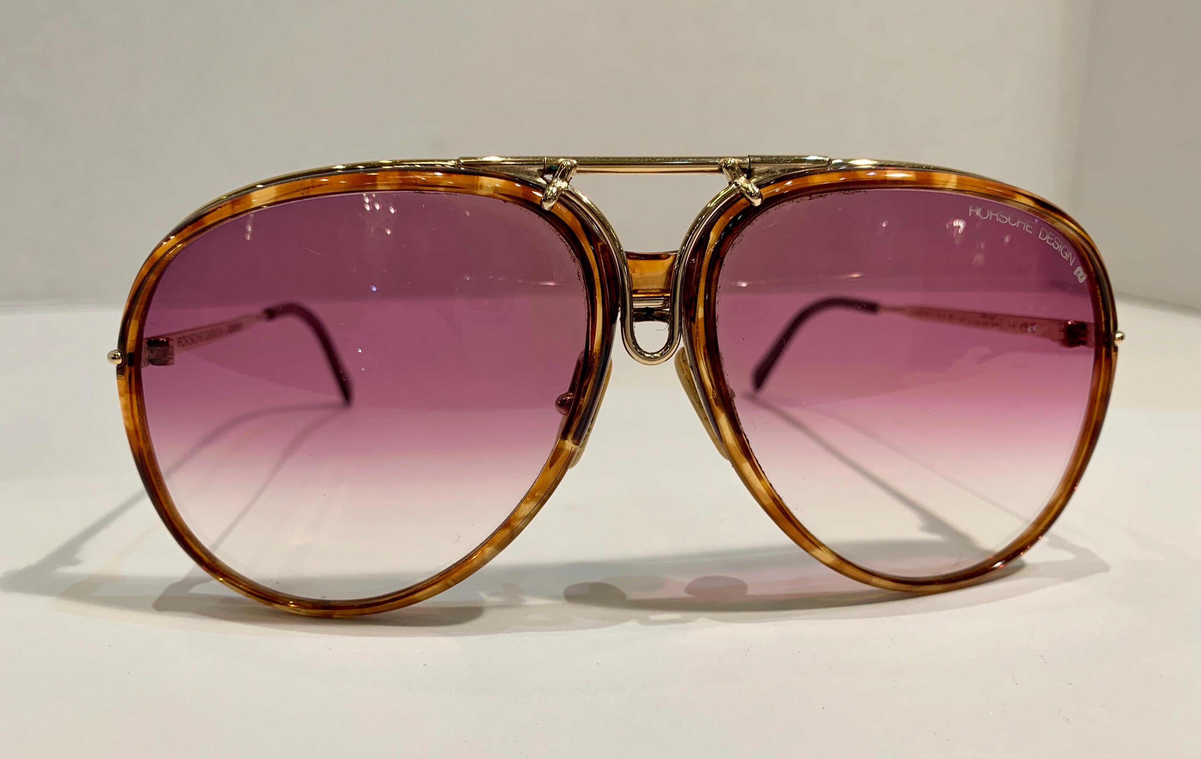 Vintage, ultra-rare 1980's innovative Porsche Design by Carrera large gold metal aviator style sunglasses.   Frame features two sets of interchangeable lenses, black lenses with black rims and rose colored lenses with tortoise shell rims.  Very