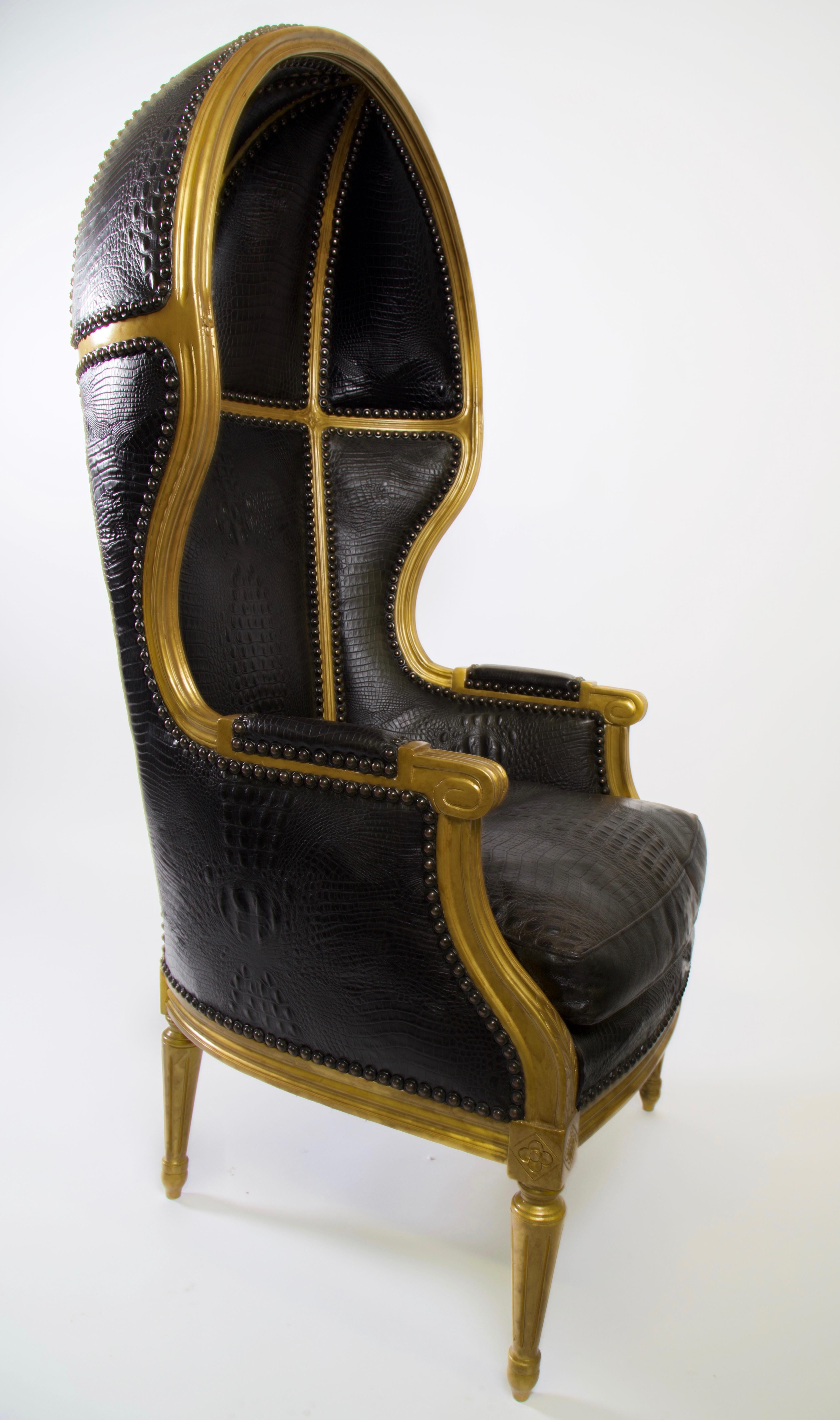 Vintage porter chair recently restored with black alligator embossed leather, modern nailhead trim, and antique gold lacquered wood. This is a show stopper. Amazing conversation piece it will command the attention in a room.

A porter's chair was